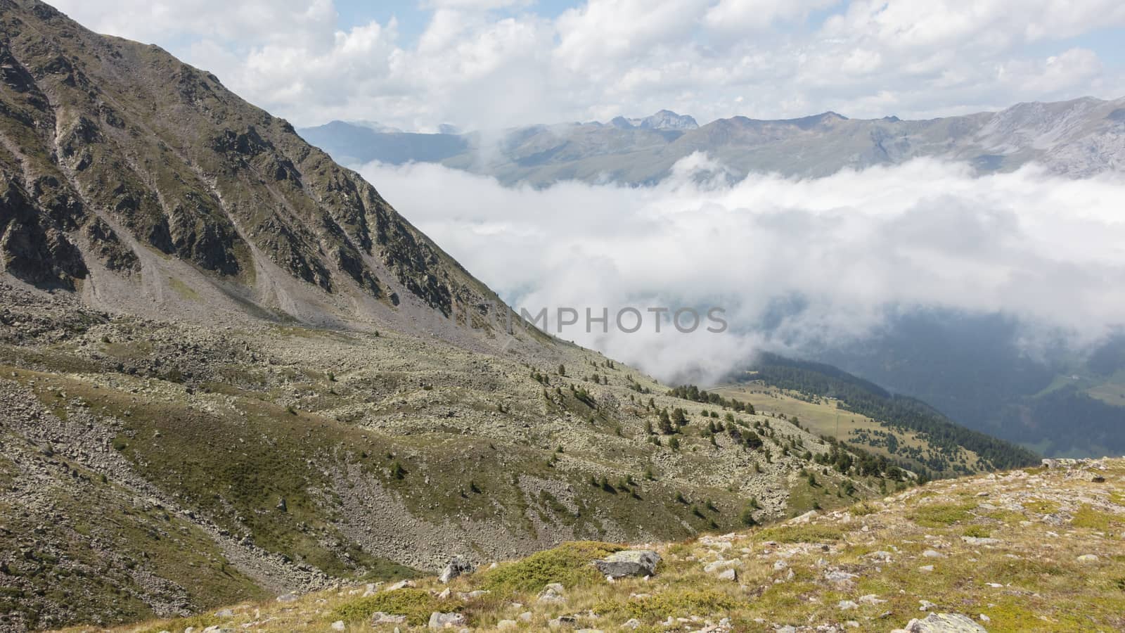 View of beautiful landscape in the Alps - Clouds rolling past the mountains