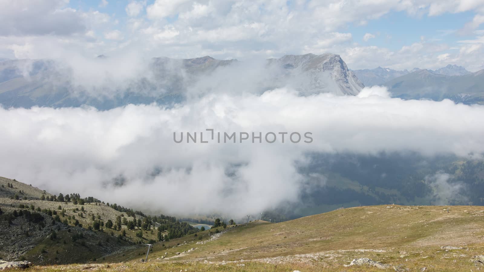 View of beautiful landscape in the Alps - Clouds rolling past the mountains