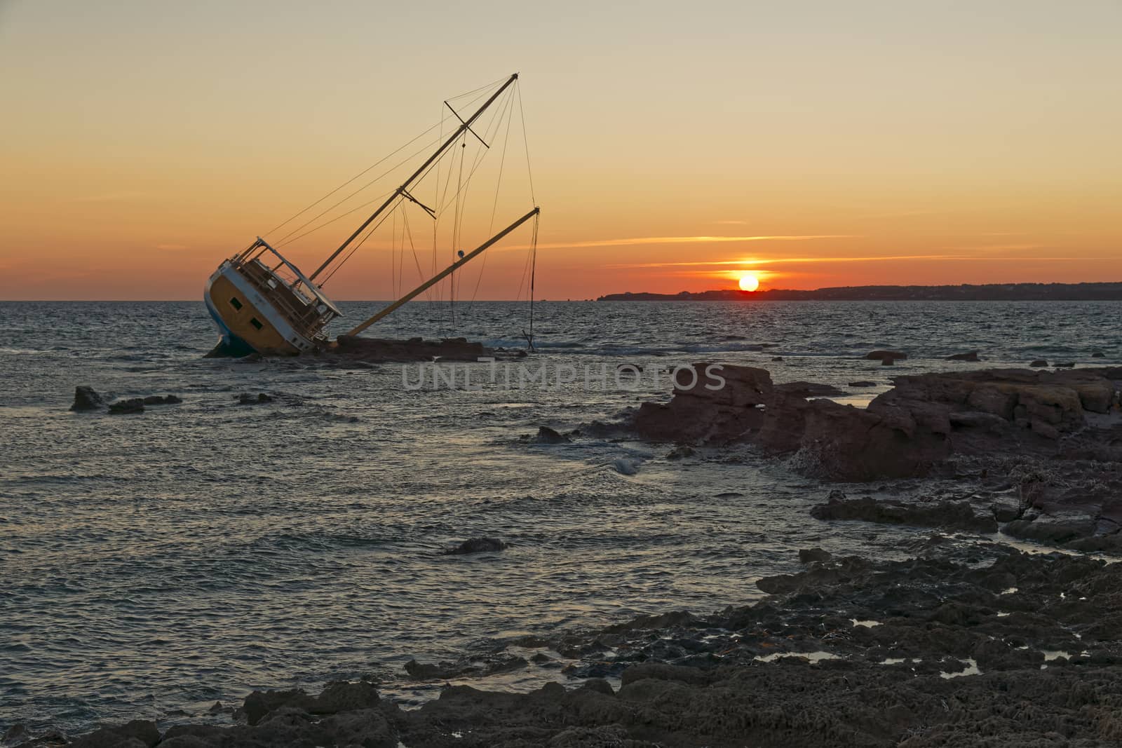 Sailboat, stranded along the coast on the cliff of Sardinia in the Mediterranean Sea.