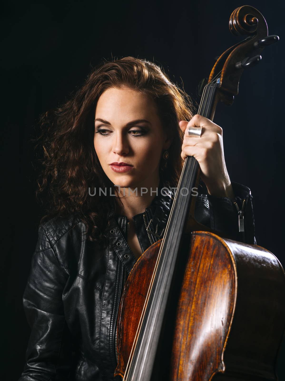Beautiful cellist holding her cello by sumners