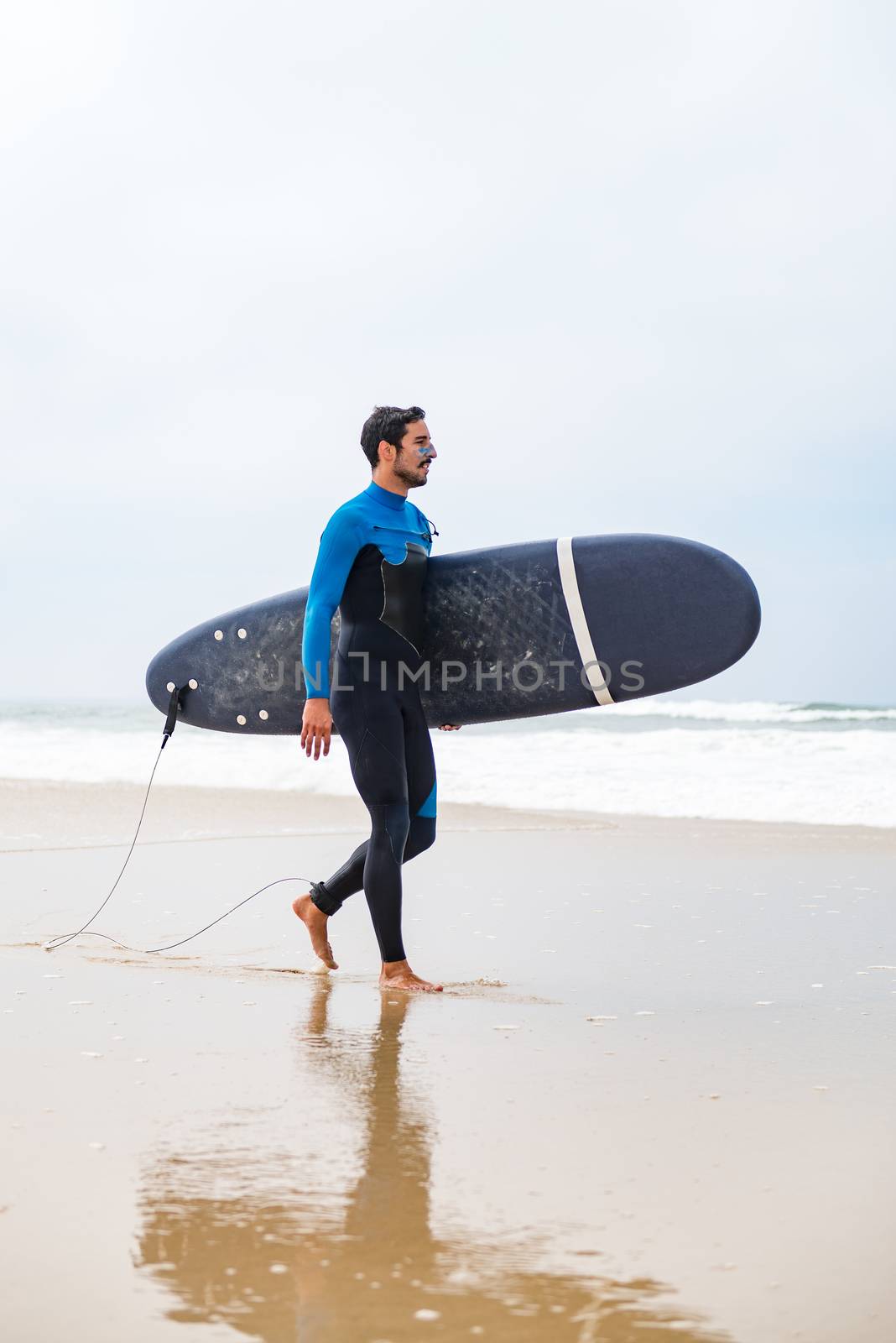 Young male surfer wearing wetsuit by homydesign