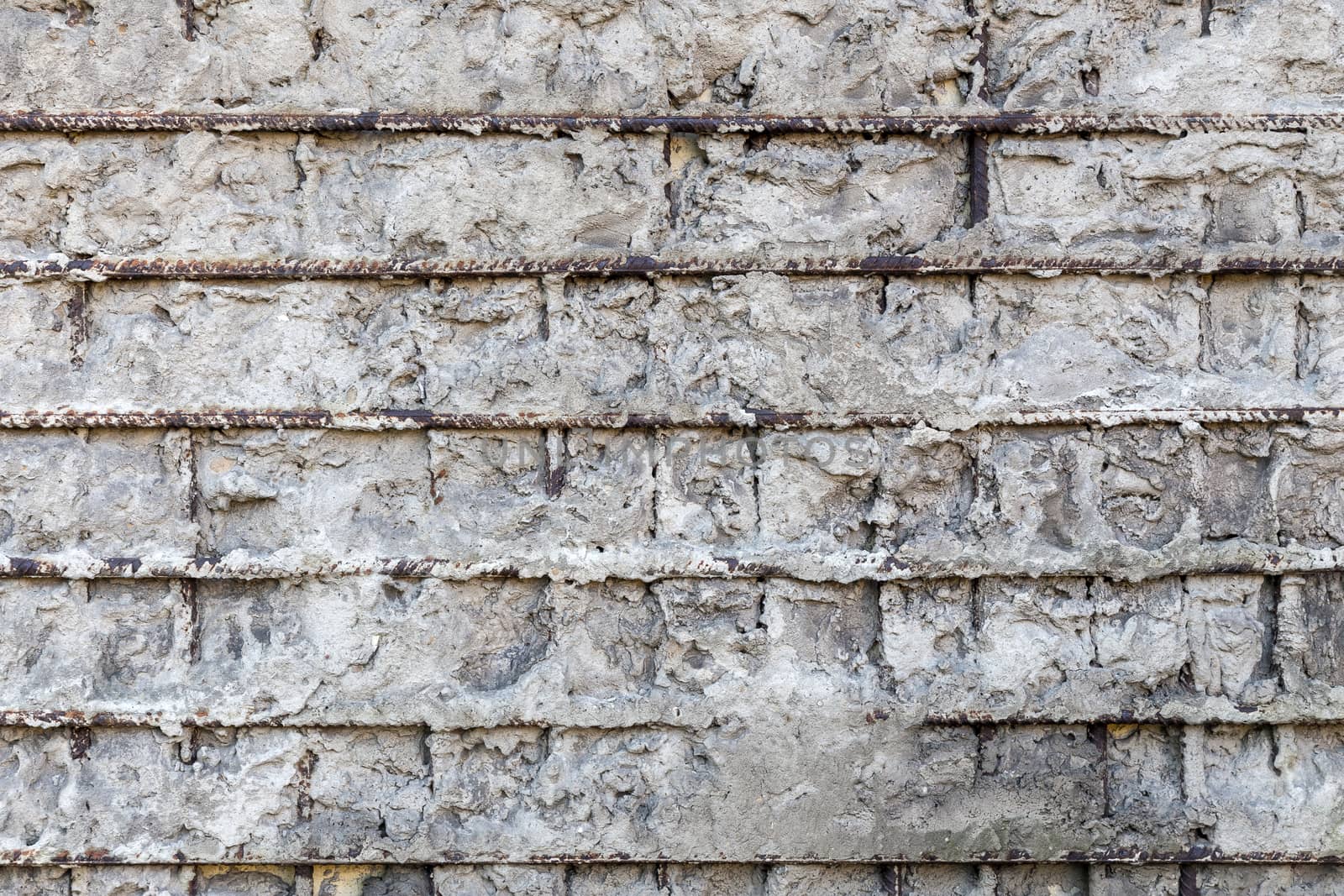 Fragment of a gray concrete wall with metal structures,background