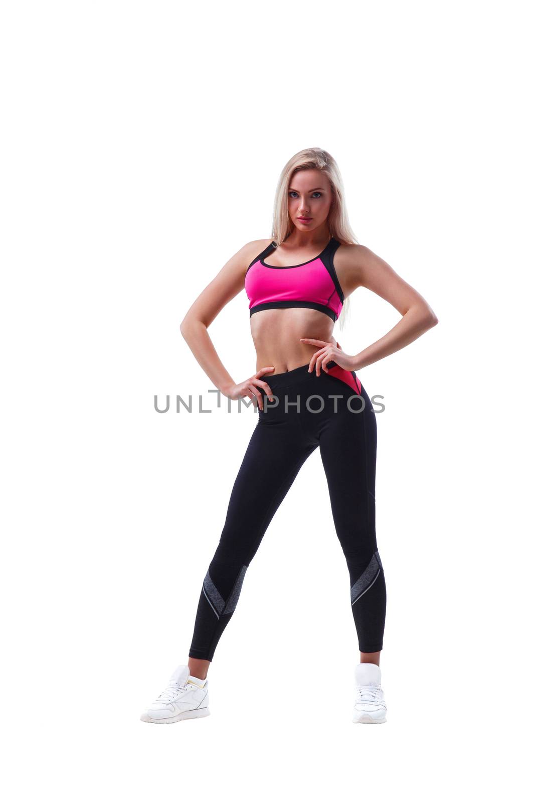 Portrait of a young fit woman in sportswear isolated on white background