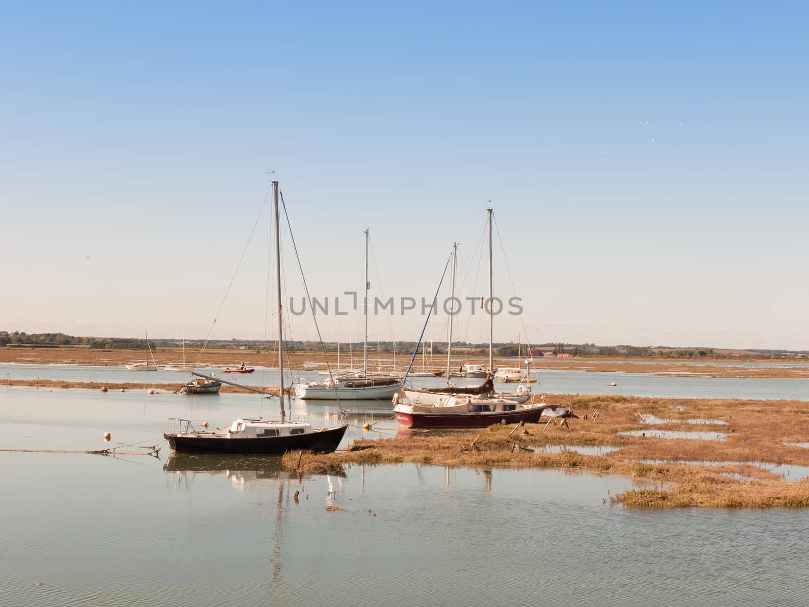 several private big boats parked in estuary with masts; essex; england; UK