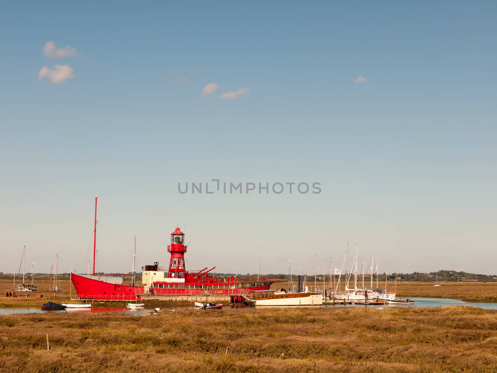 red life boat moored in tollesbury maldon estuary blue sky by callumrc