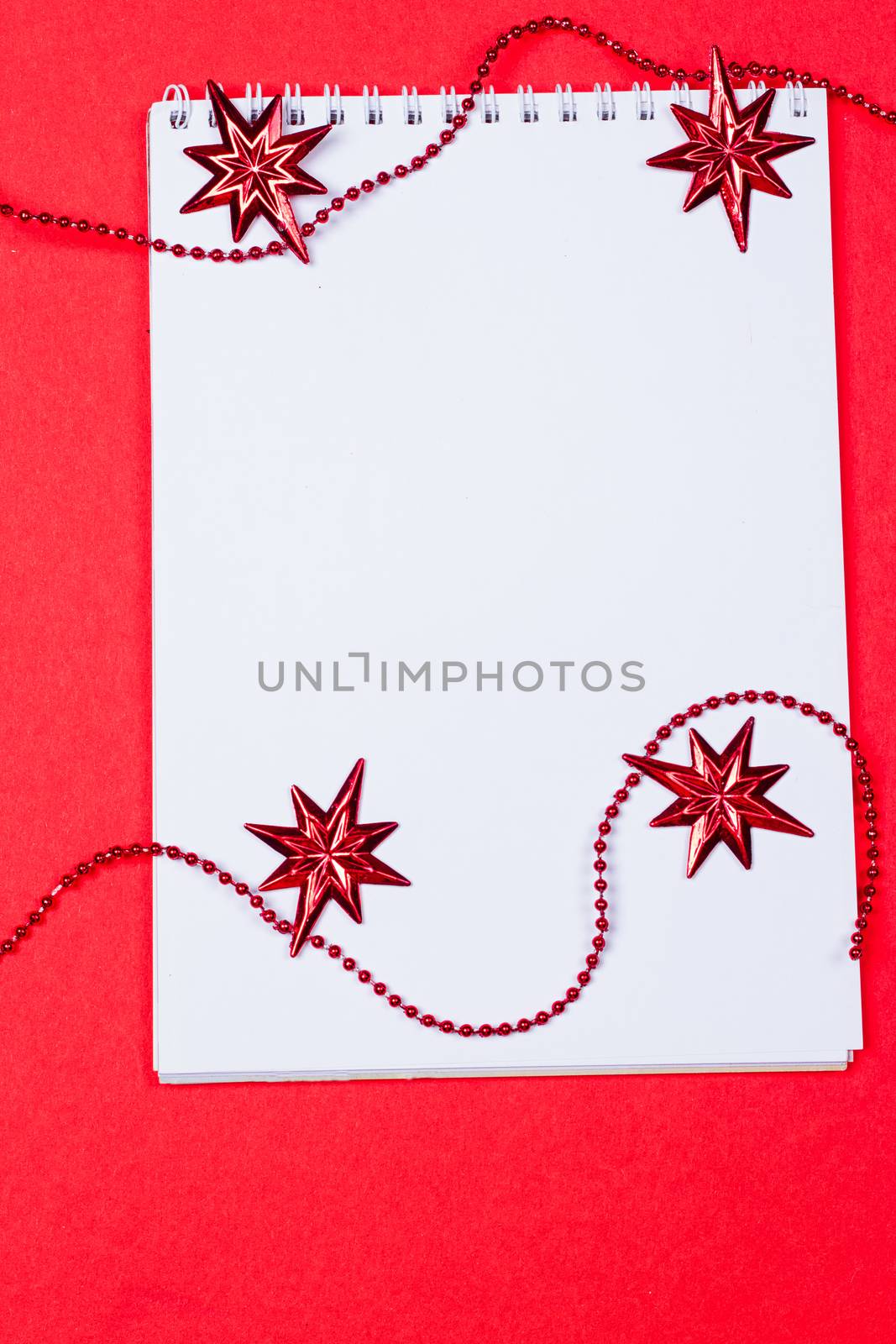 Holiday decorations and notebook on red background