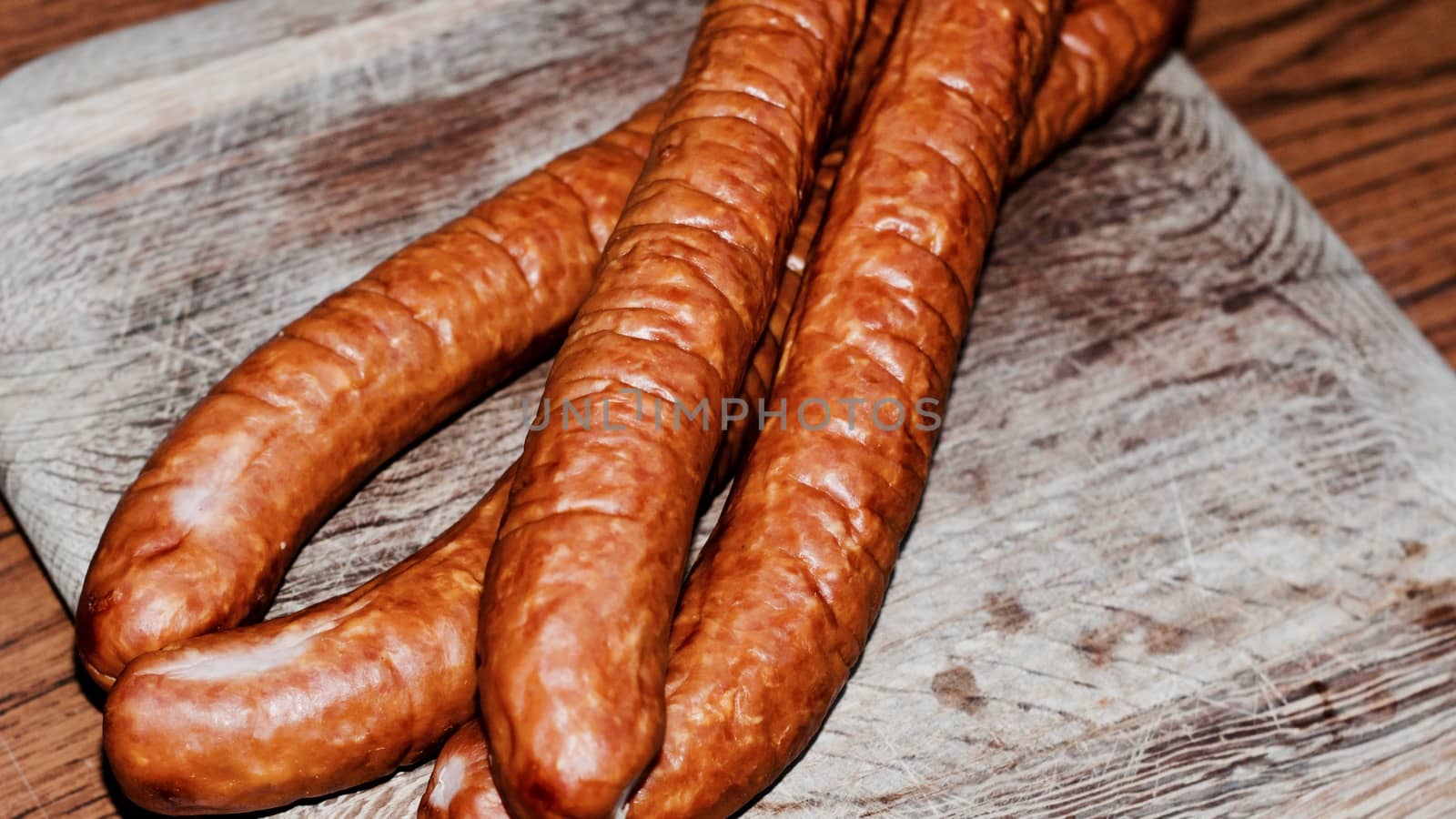 Fresh and tasty sausages on the wooden board. BBQ concept.
