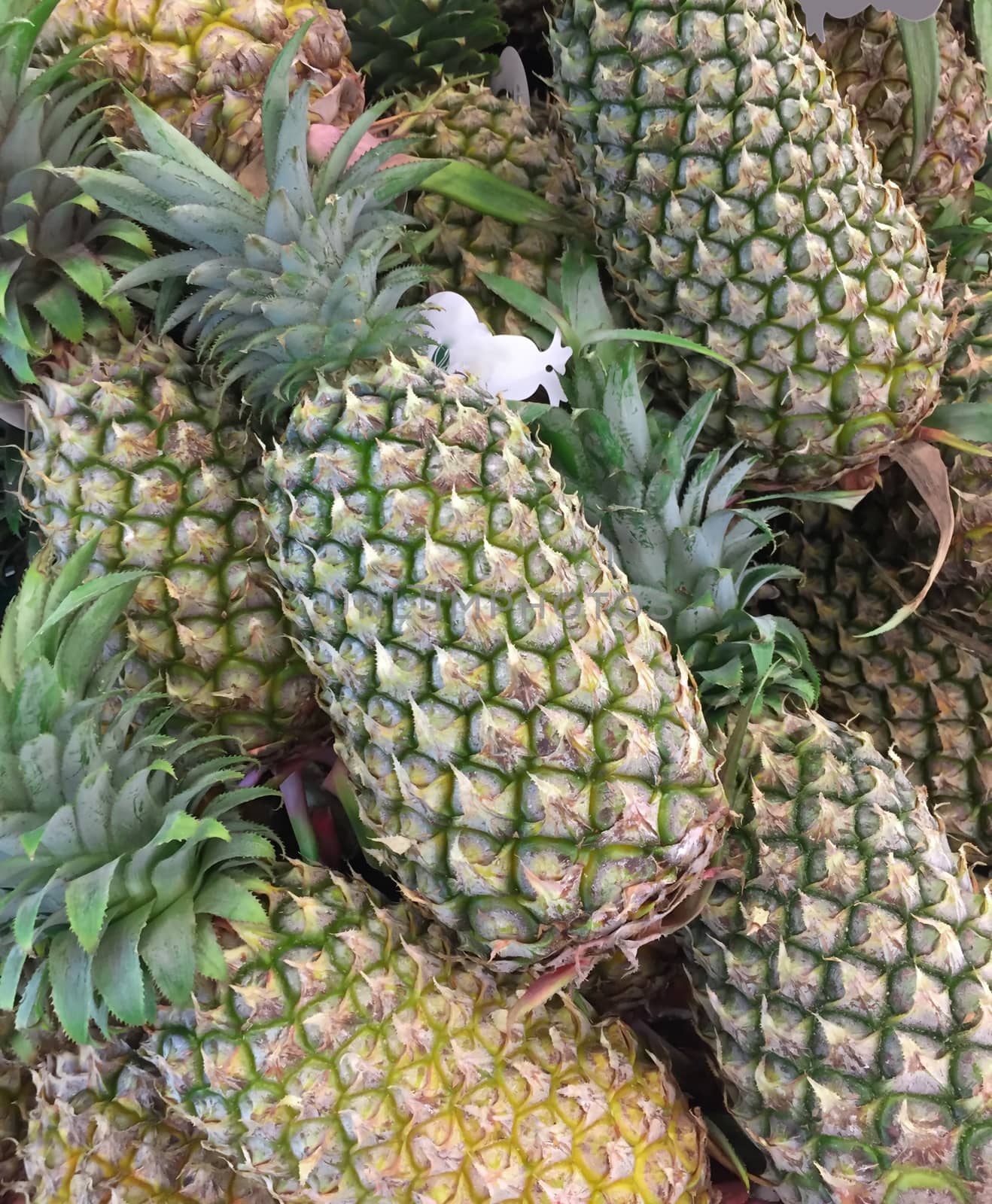 Closeup fresh pineapples fruit in supermarket, Photo with mobile phone