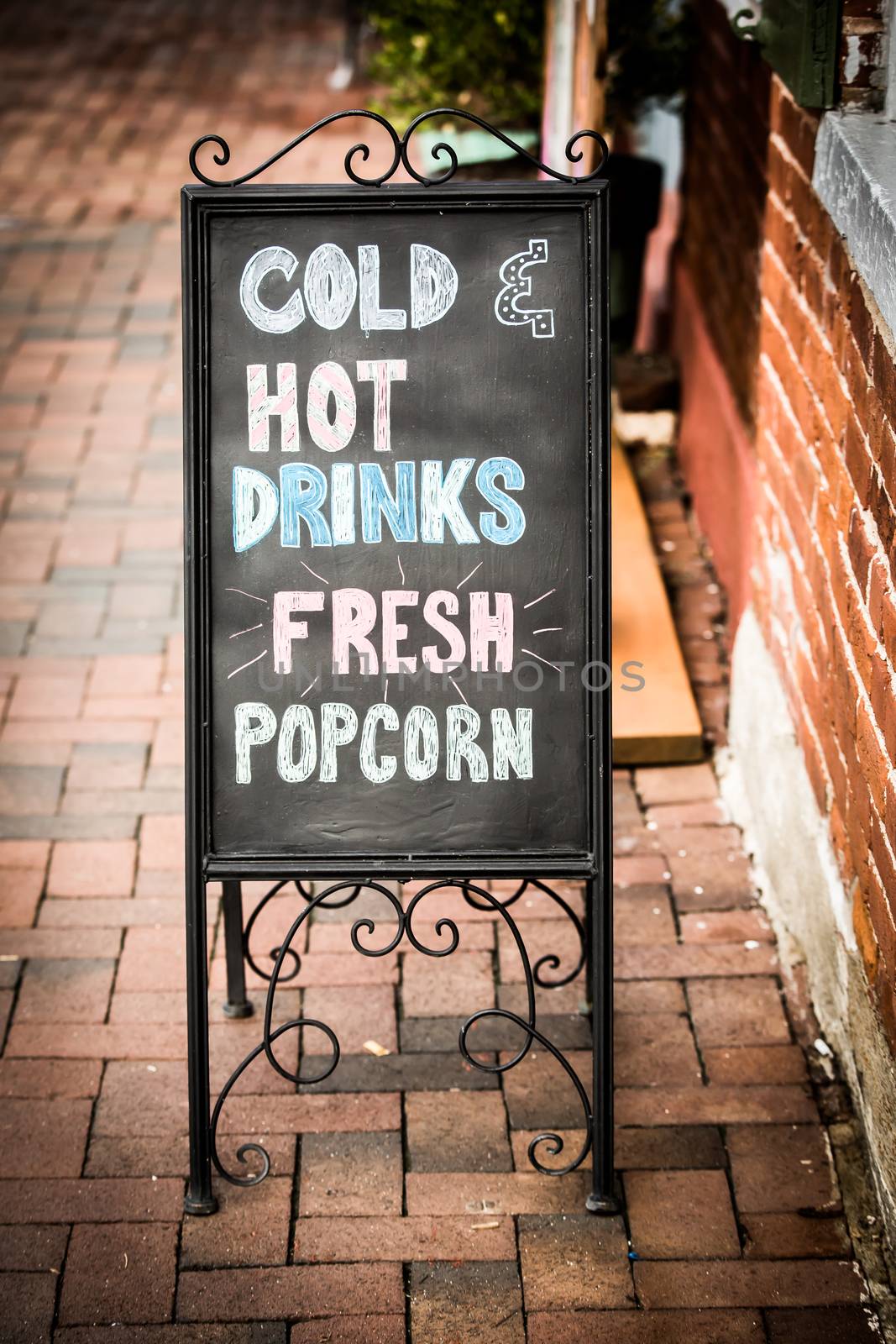 A vintage black chalkboard with Cold Hot Drinks and Fresh Popcorn written on the front.