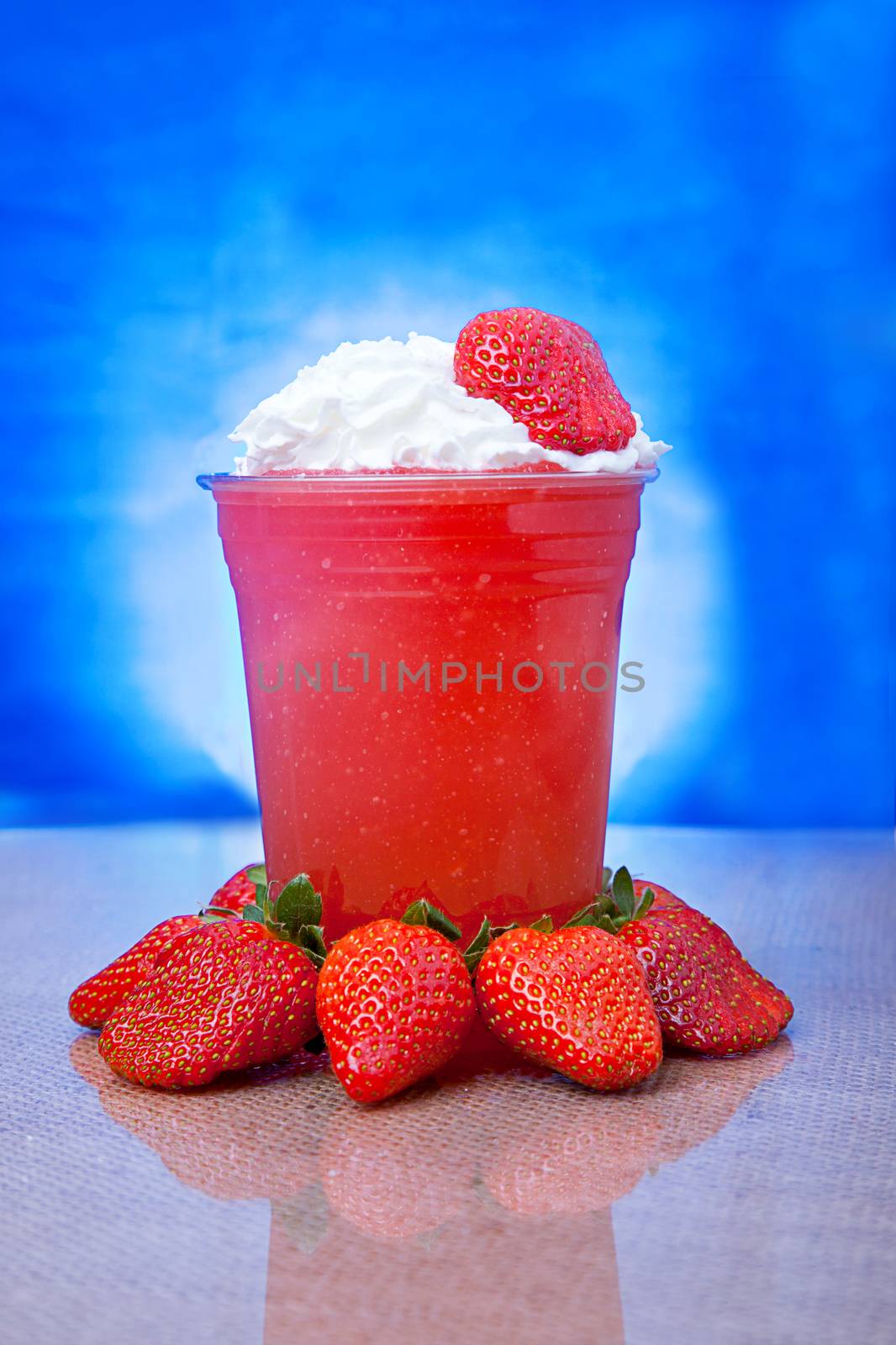 Beautiful frozen strawberry drink topped with whipped cream and sliced strawberries.