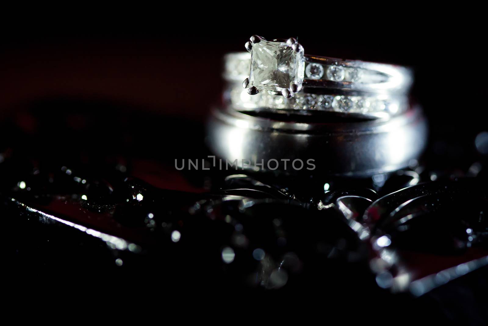 Beautiful diamond wedding rings in a black textured background.