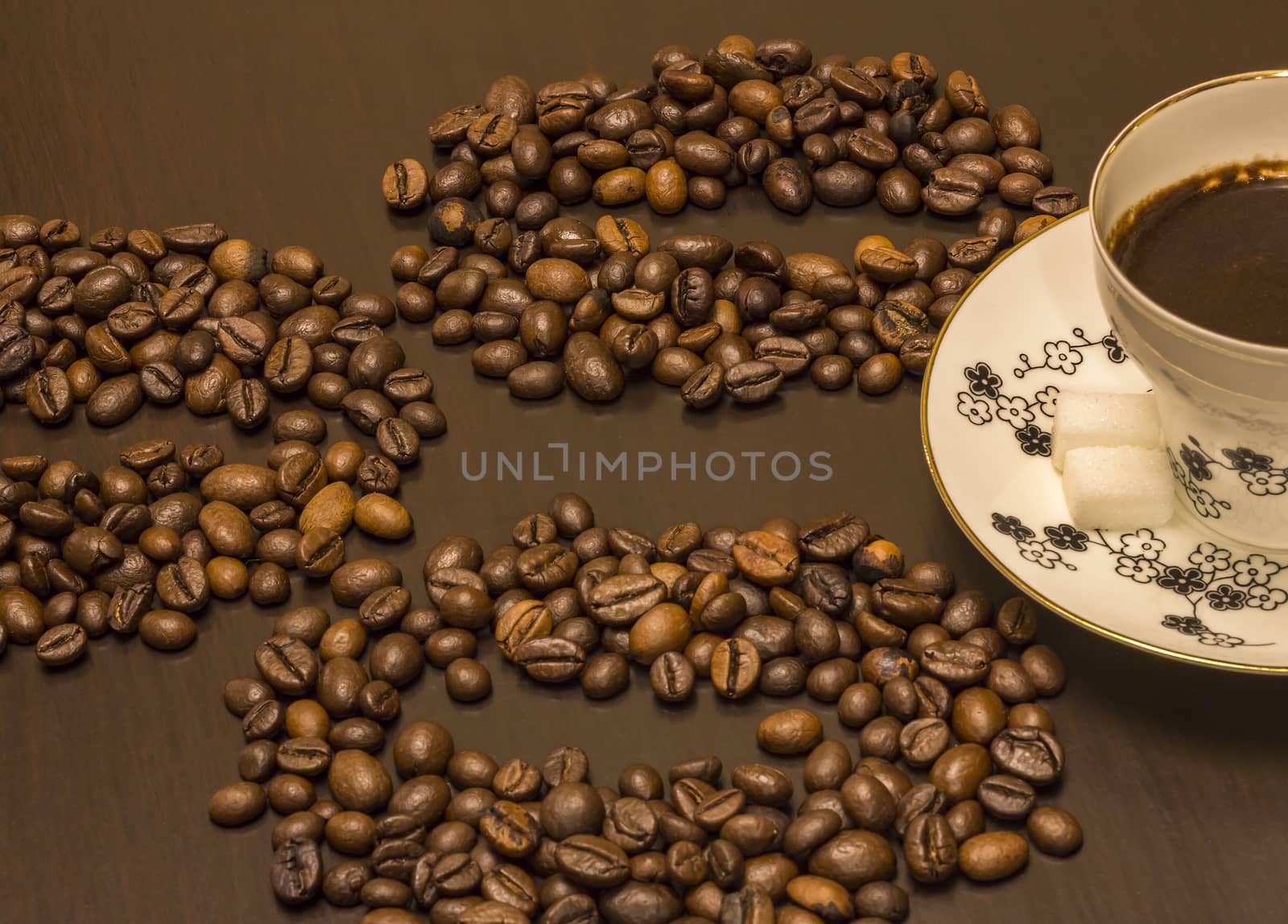 A cup of coffee and coffee beans on the table.