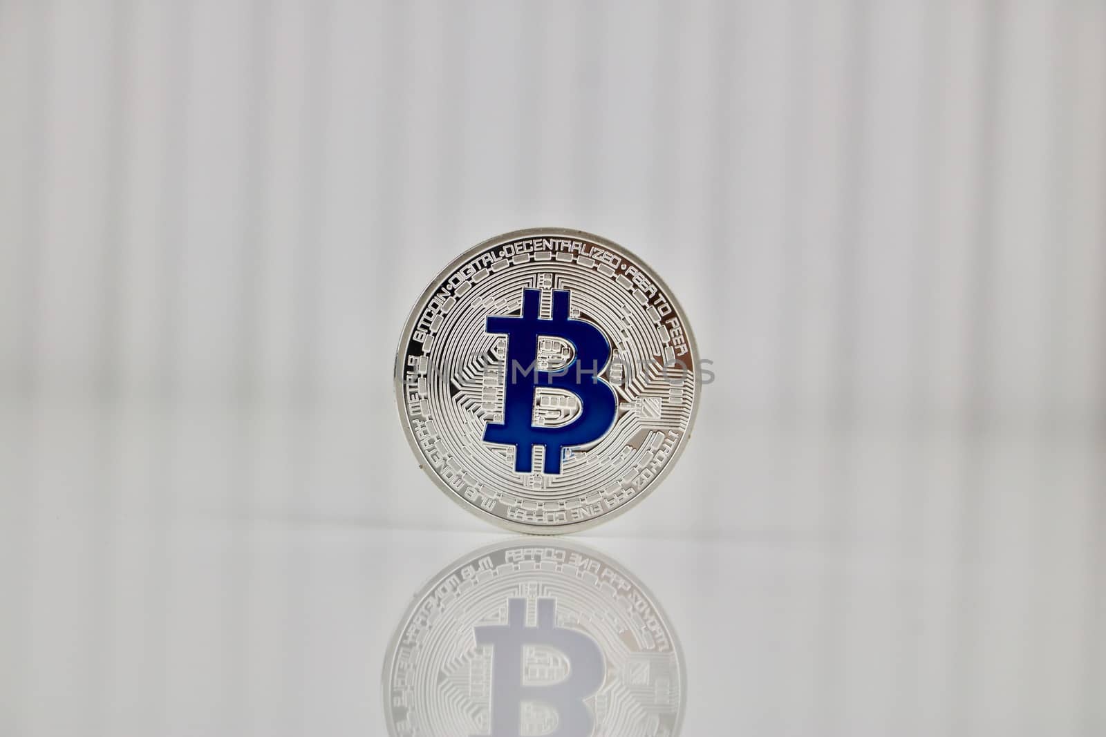 Digital currency physcial blue bitcoin coin on white background.