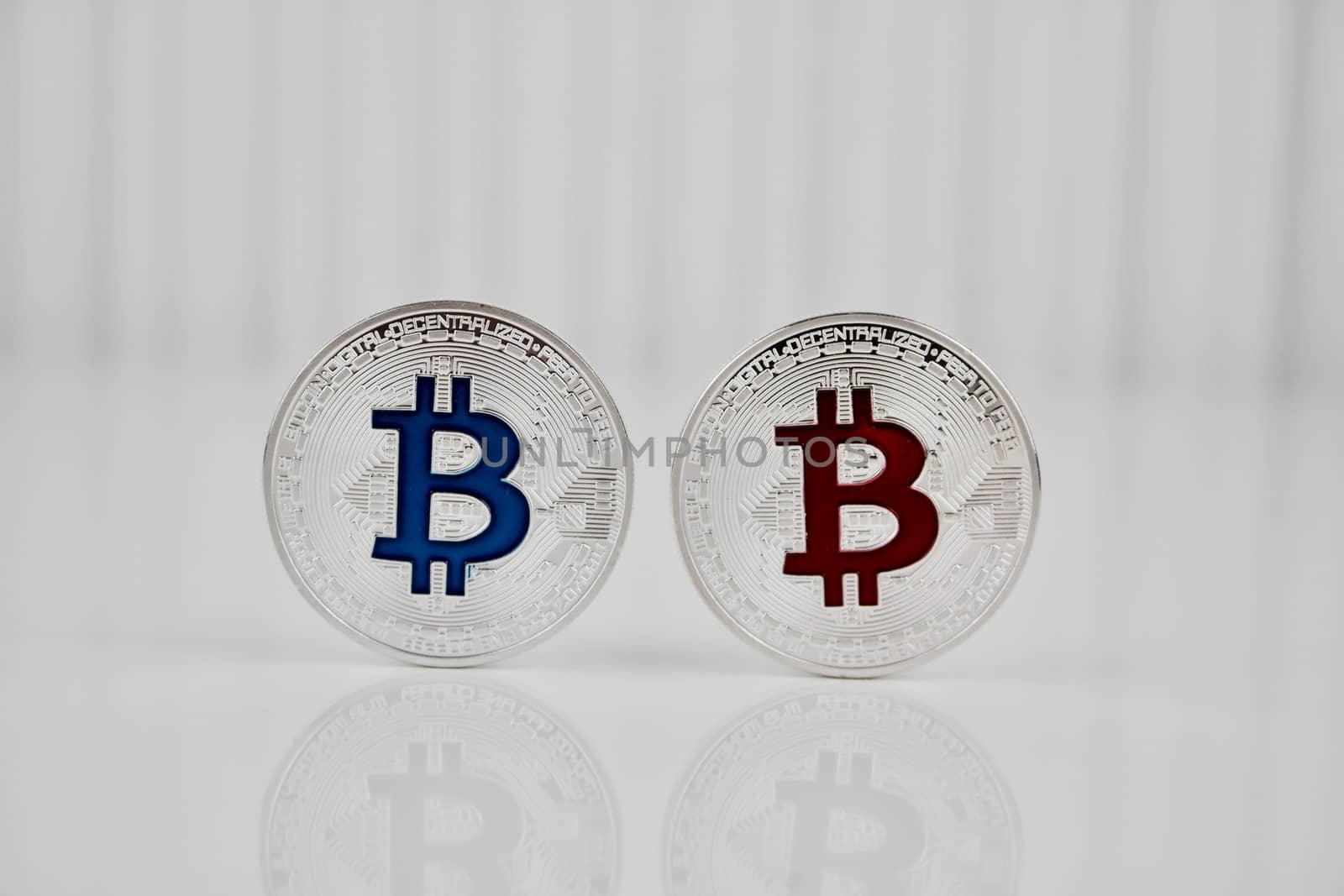 Digital currency physical silver bitcoin coin with blue and red sign.