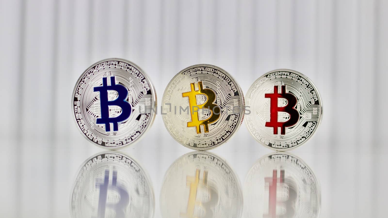 Digital currency physical silver colorful bitcoins on white table.