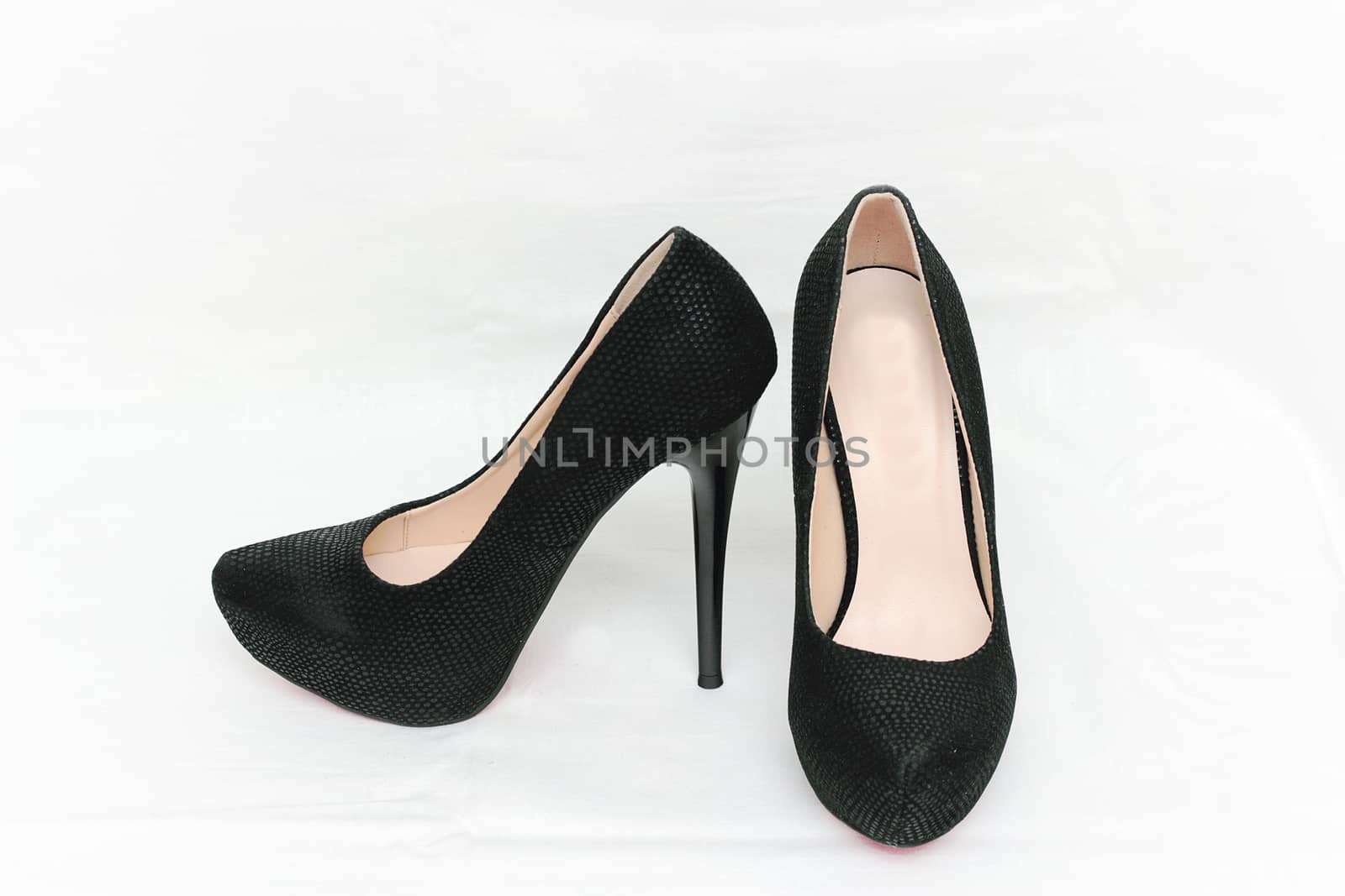 Female shoes with heels of black color isolated against white background.