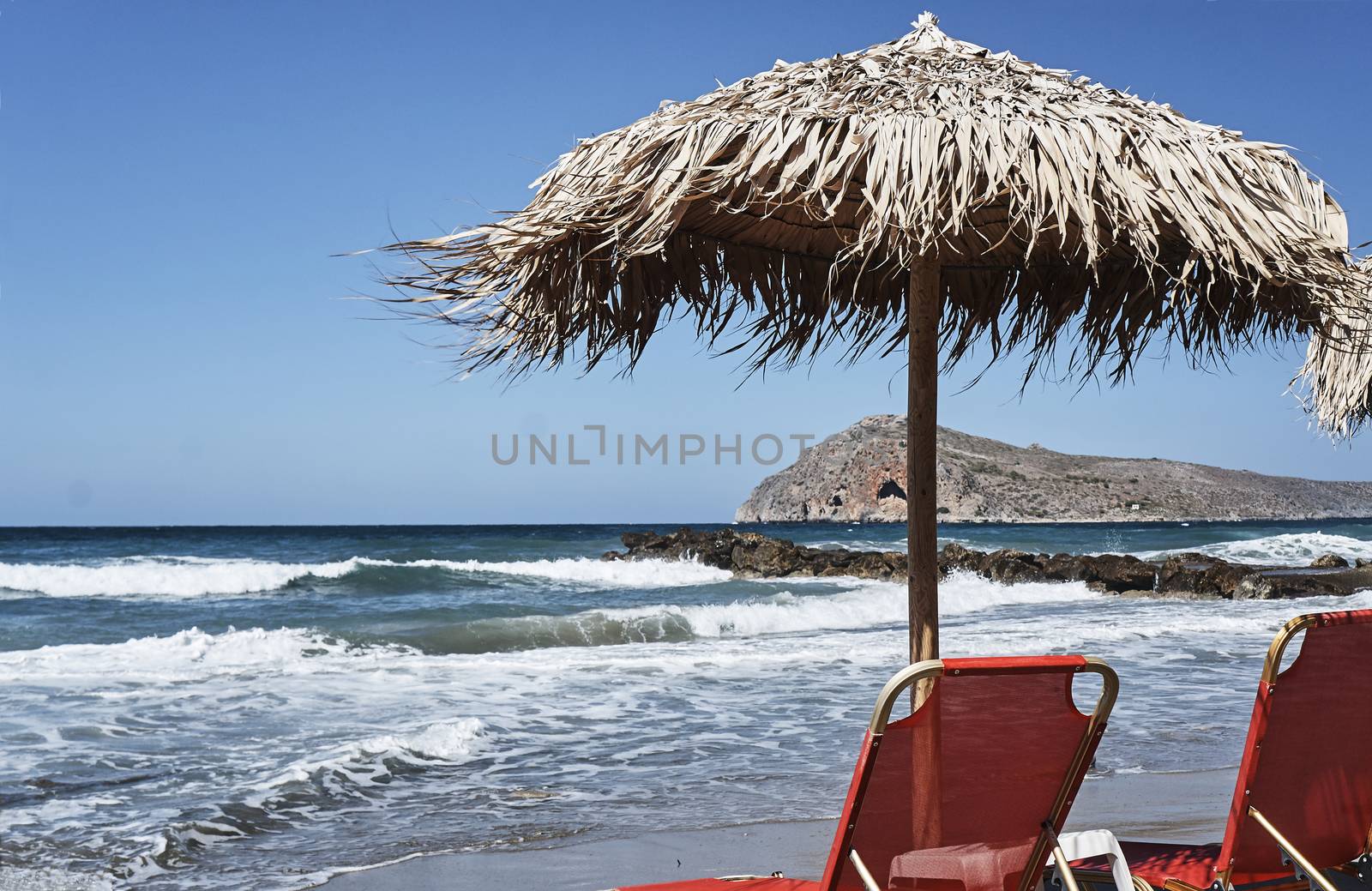 Sunbeds and umbrellas on the beach on the island of Crete, Greece