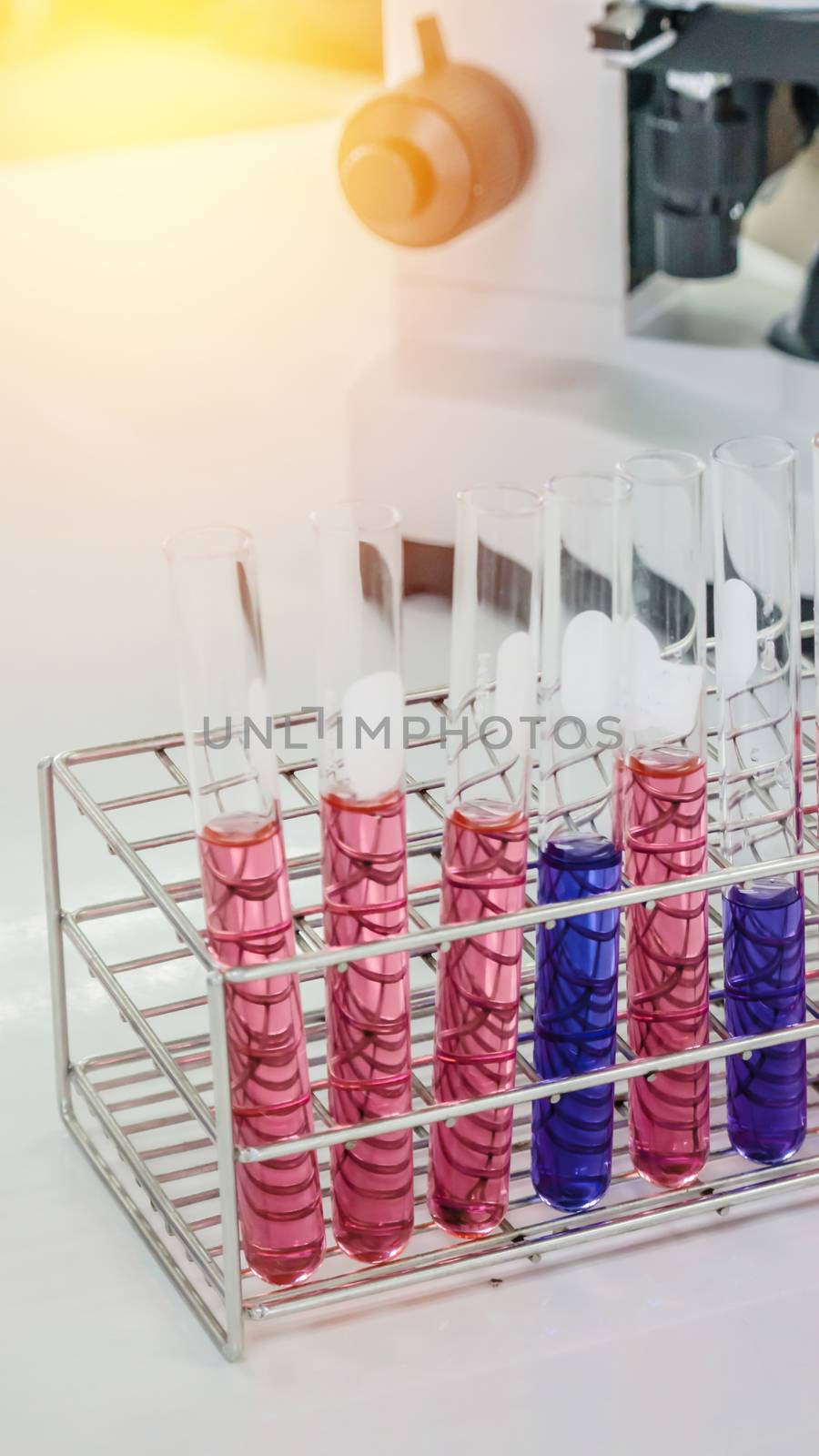 Different laboratory test tubes with colored liquid and with reflection