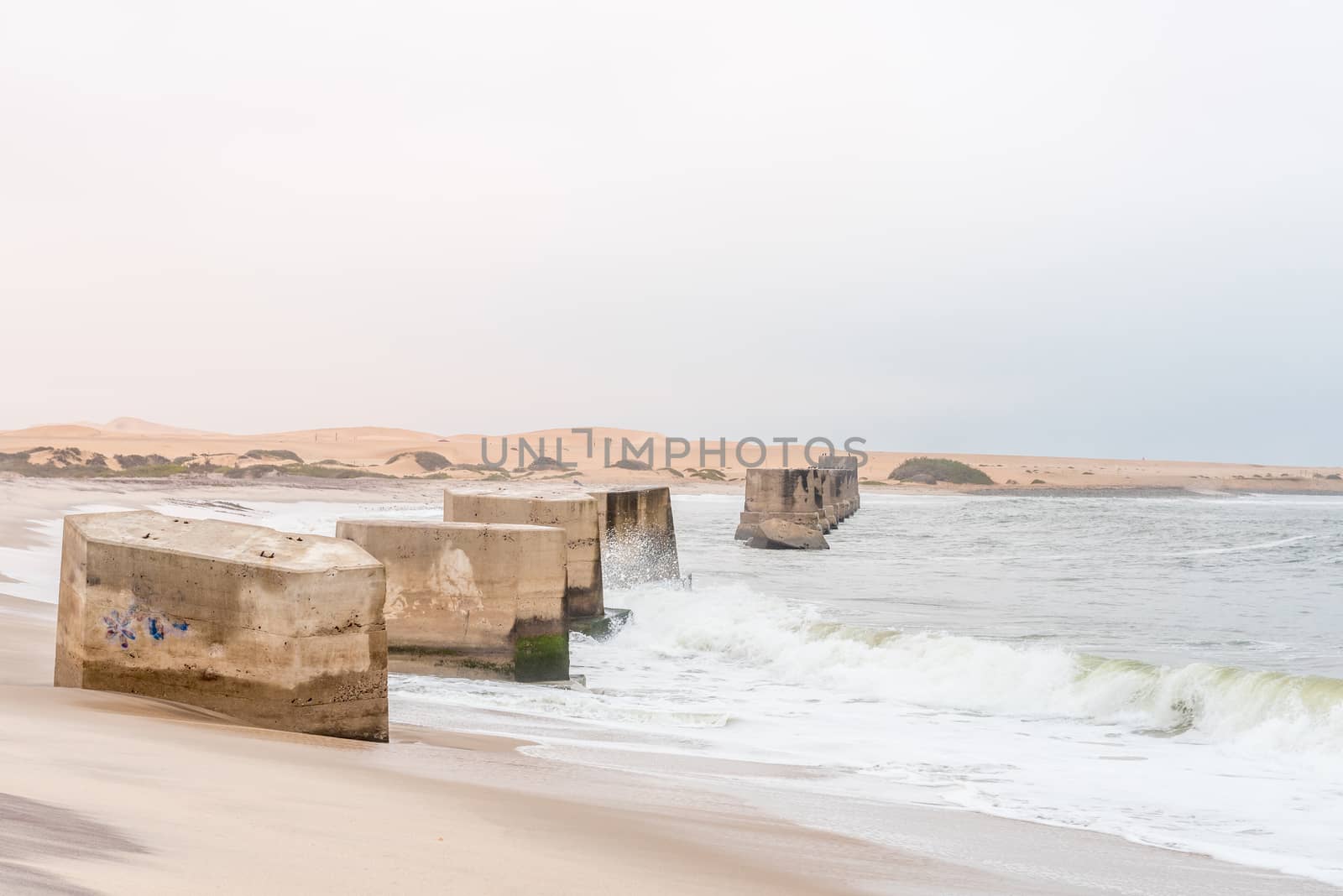 Pillars of the old railroad bridge over the mouth of the Swakop River at Swakopmund in the Namib Desert on the Atlantic Coast of Namibia
