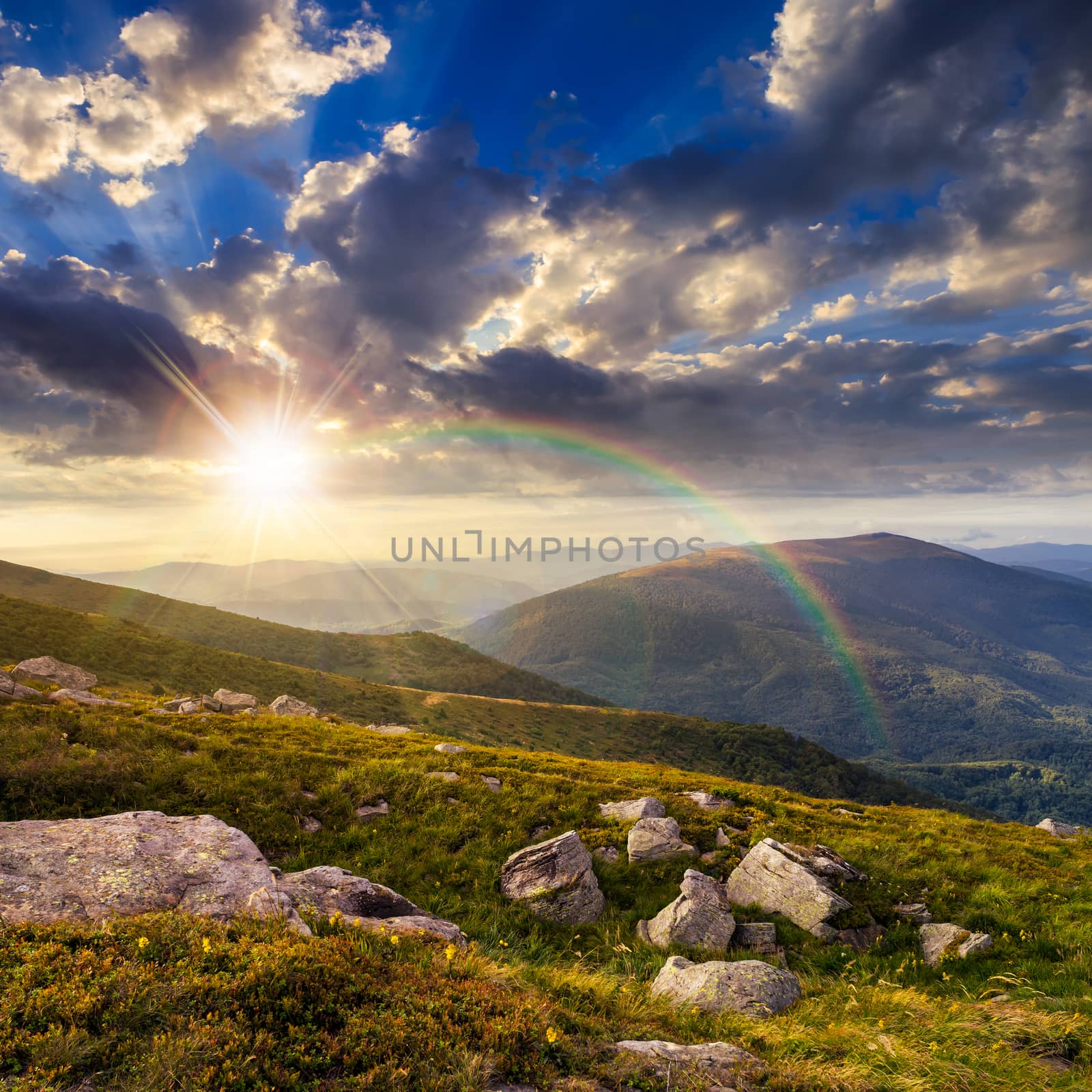 composite mountain landscape. valley with white sharp boulders on the hillside edge in high mountain in sunset light with rainbow