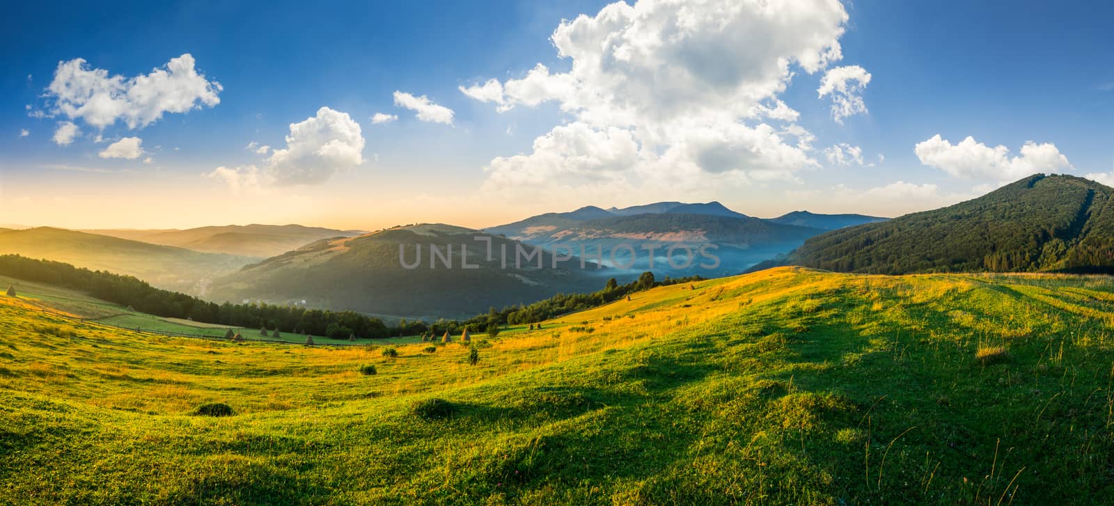 agricultural field on hillside in mountains near village in morning light