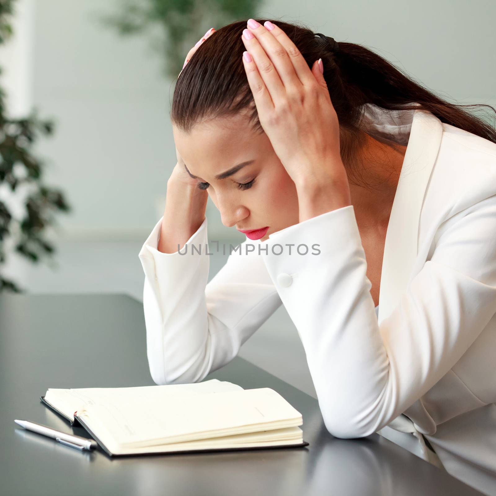 Tired young woman with headache in an office