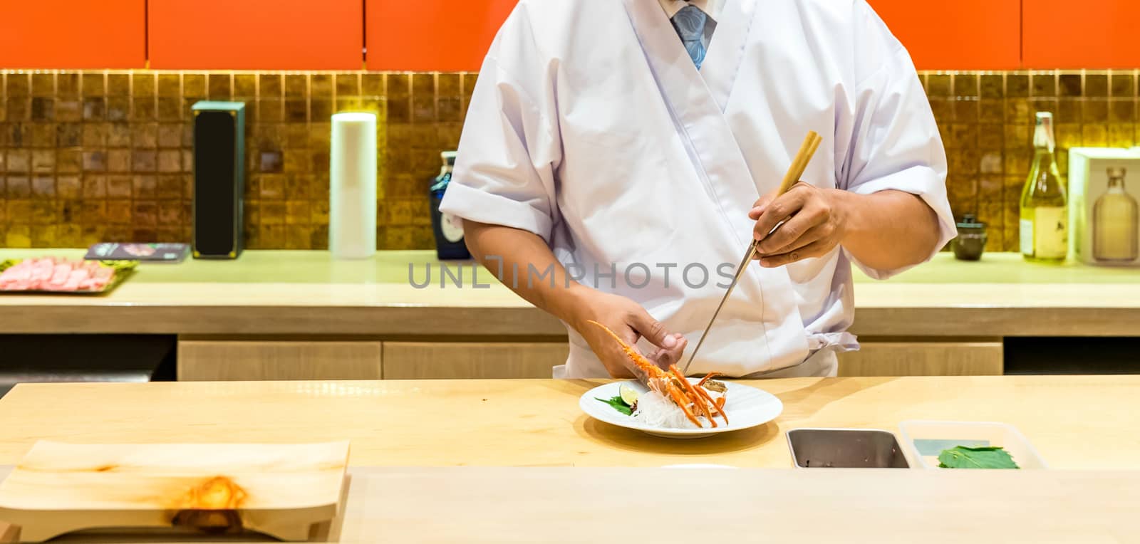 Chef preparing and cooking lobster sashimi