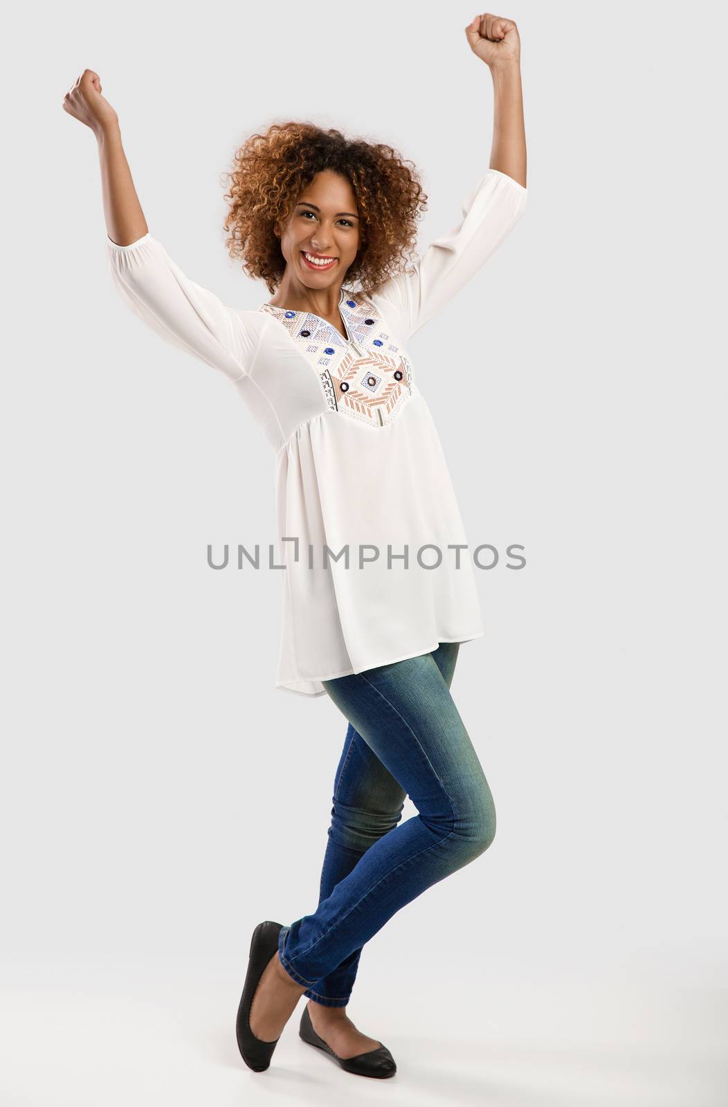 Beautiful and happy African American woman with arms raiaed