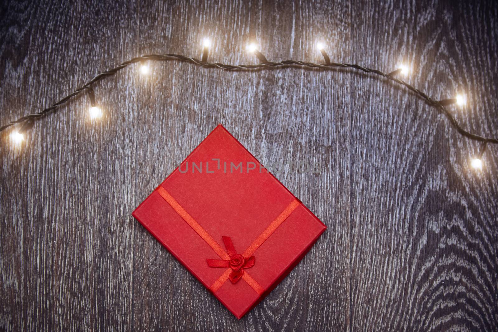 Christmas light and gift box on a hardwood background