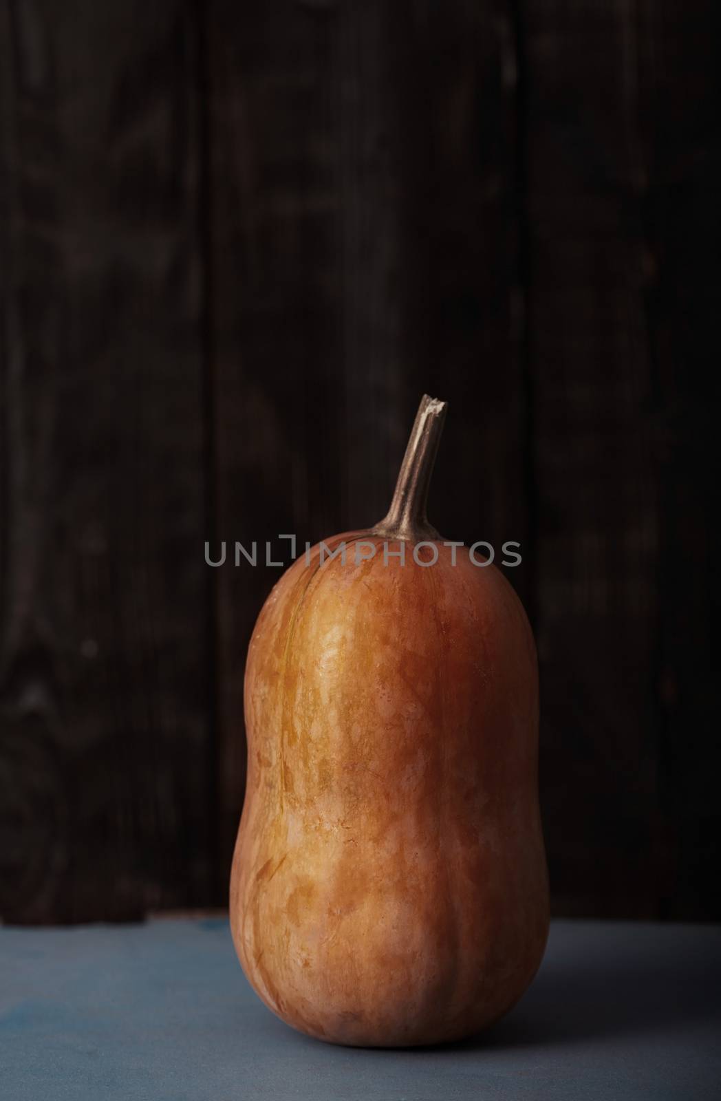 Orange pumpkin on a table. Vertical photo