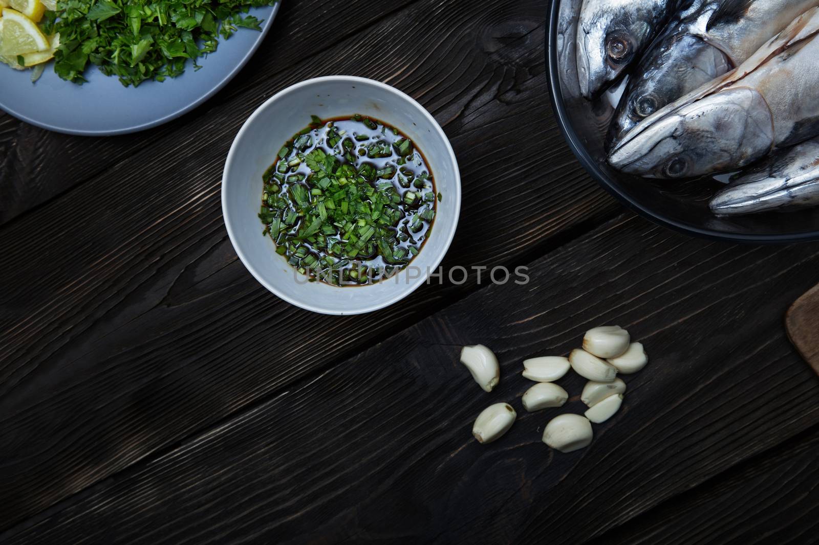 Fish with herbs and vegetables on a wooden table