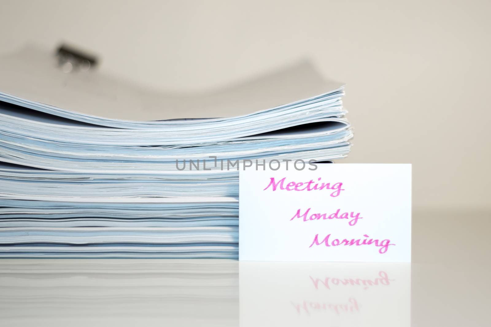 Meeting Monday Morning; Stack of Documents on white desk and Background.