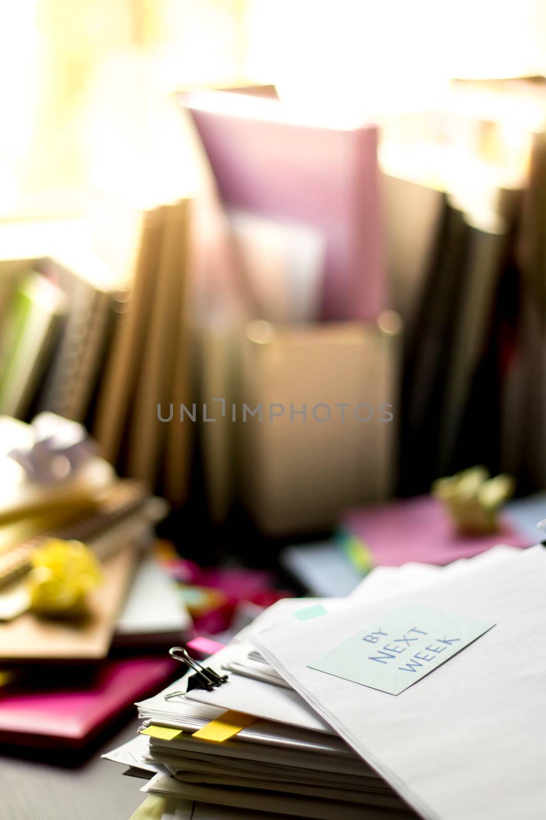 By Next Week; Stack of Documents. Working or Studying at messy desk.