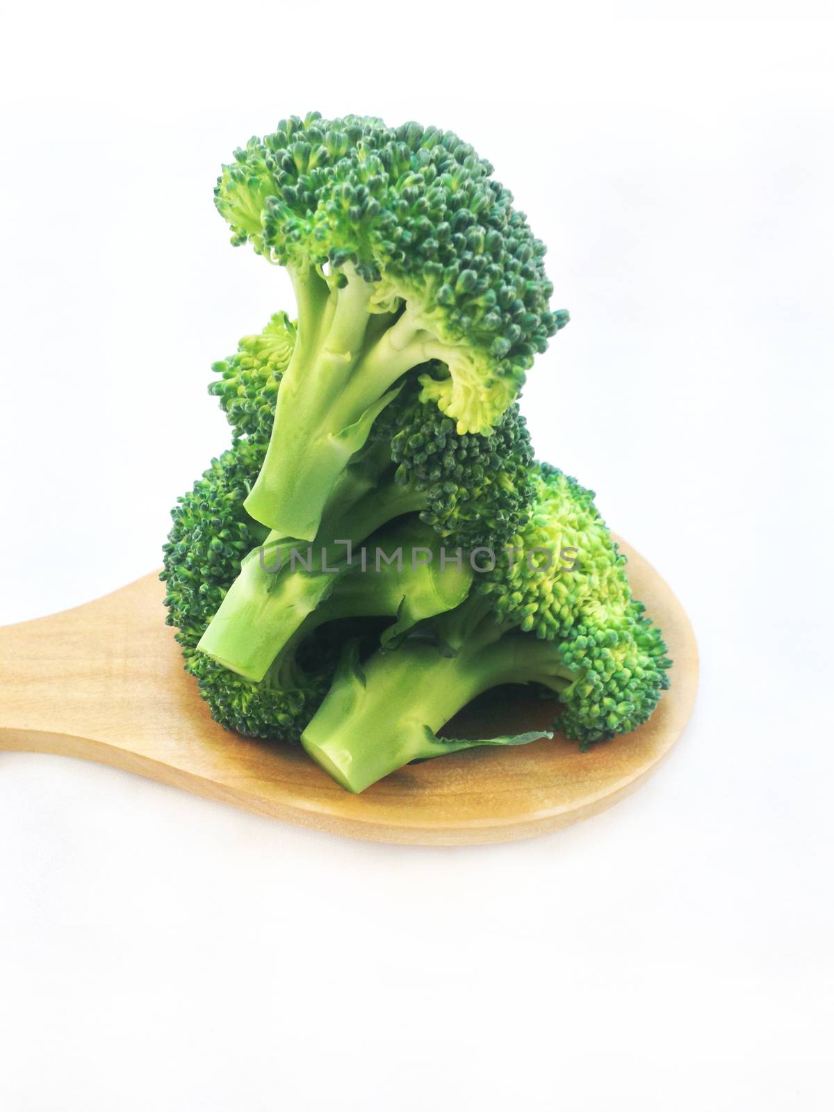 Broccoli isolated with wooden ladle on white background