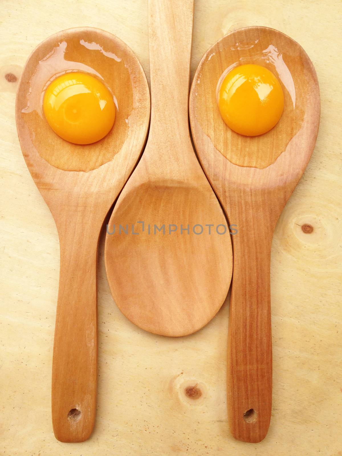 Eggs on wooden spoon by Bowonpat