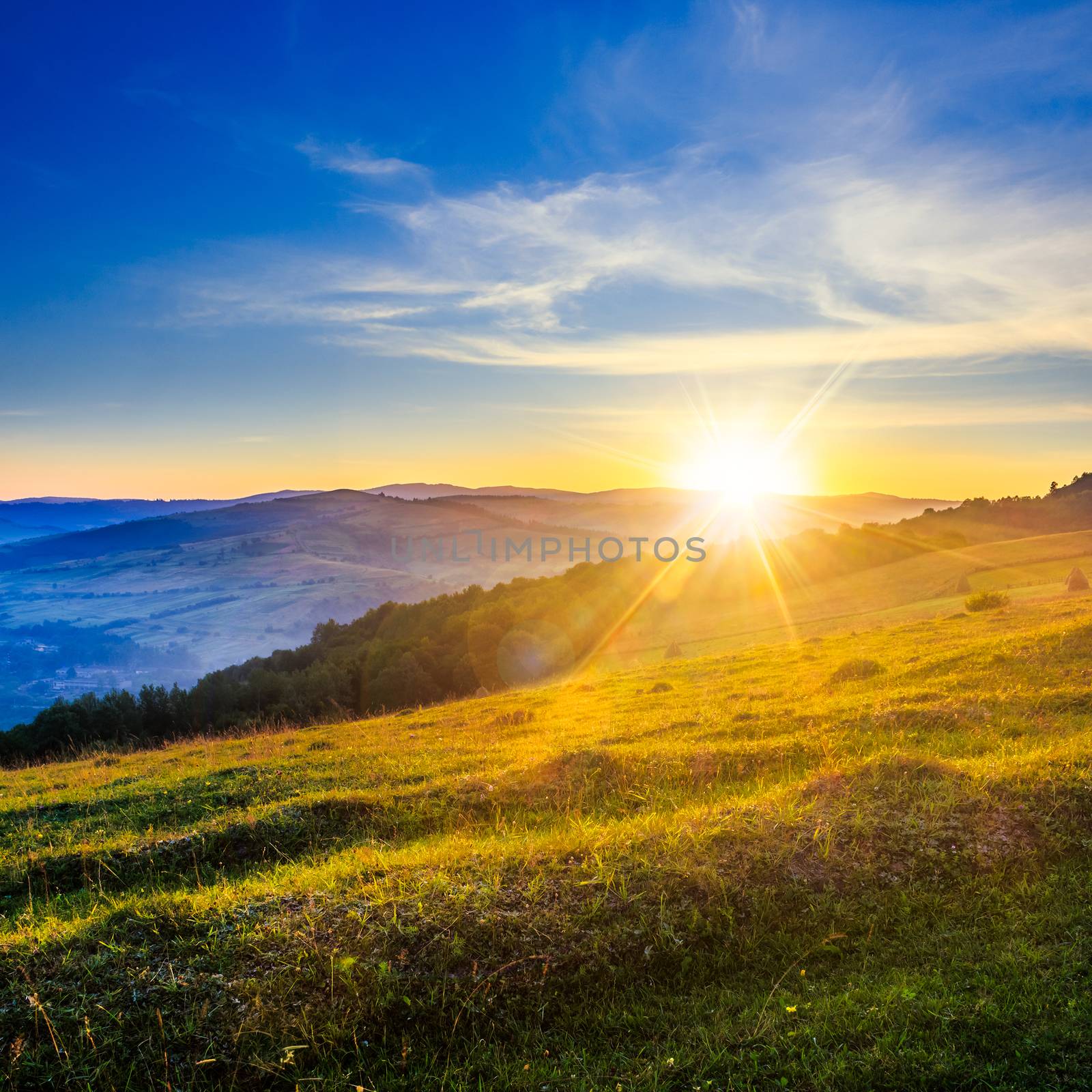 HDR sunrise in agricultural field on hillside in mountains near village