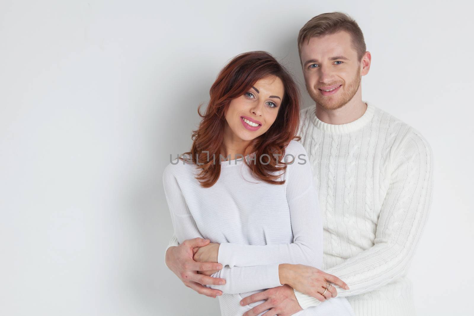 Portrait of young smiling couple in white