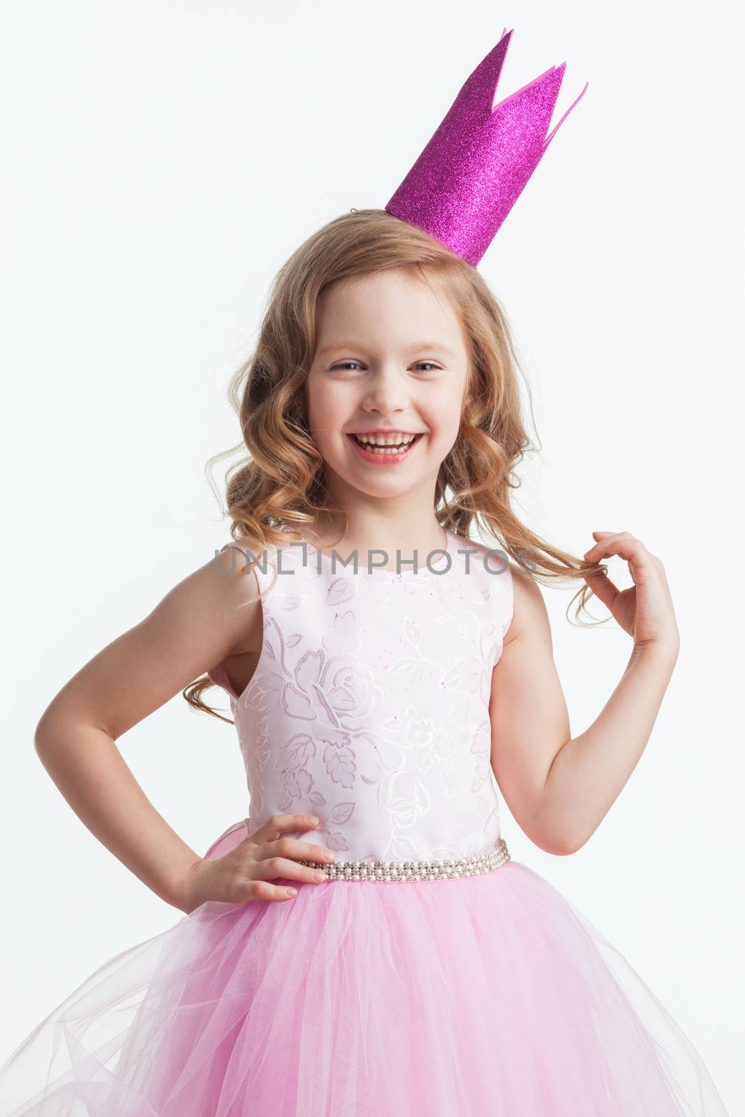 Happy small princess girl in pink dress and crown isolated on white background