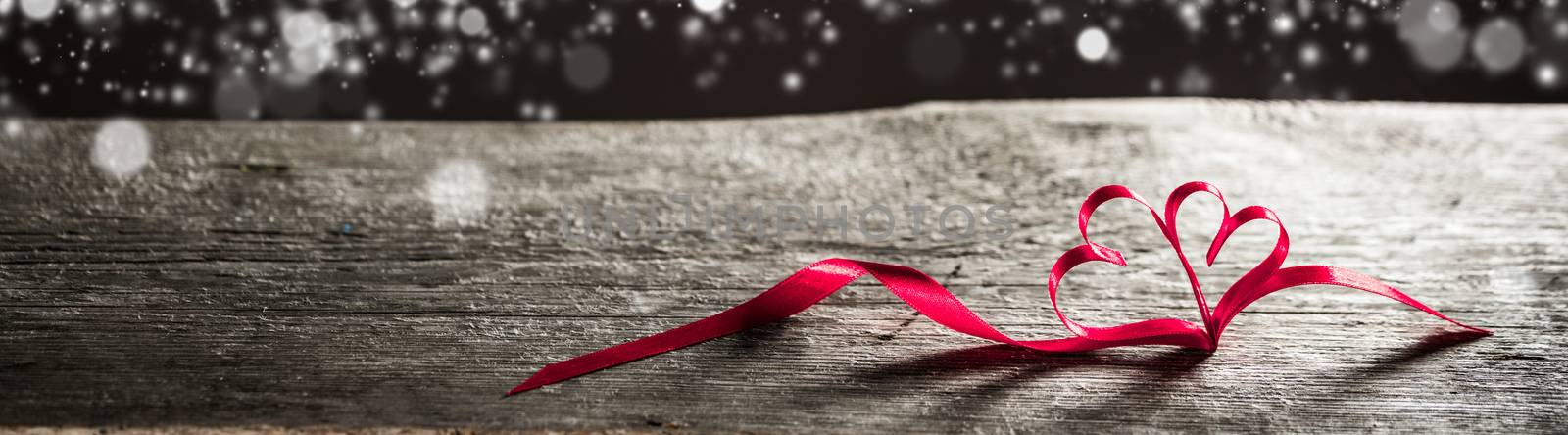 Two red ribbon magic hearts on wooden backround, Valentine day concept