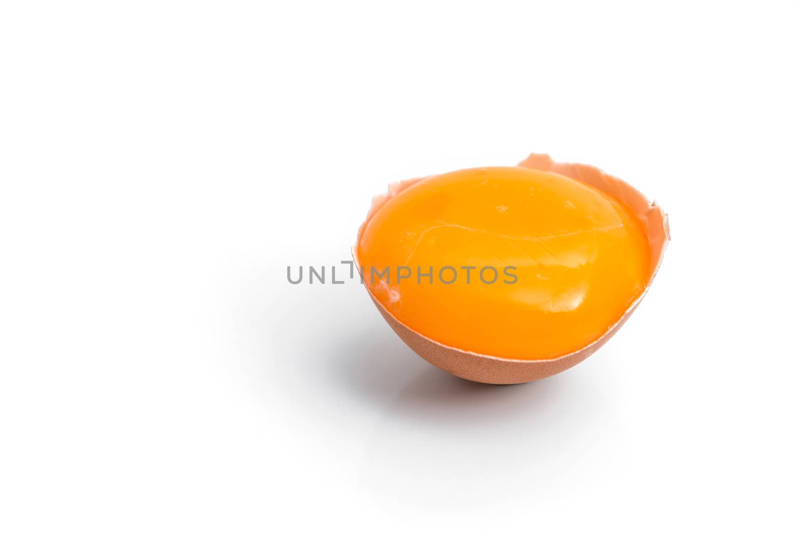 egg yolk in egg shell, cracked egg white isolated on white backg by antpkr