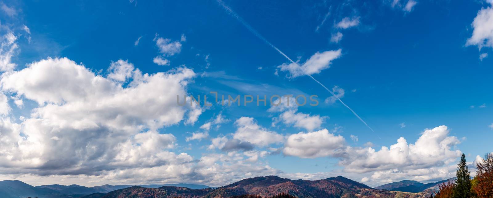 beautiful cloudscape over the mountain ridge. lovely nature background with blue sky and fluffy clouds on autumn day