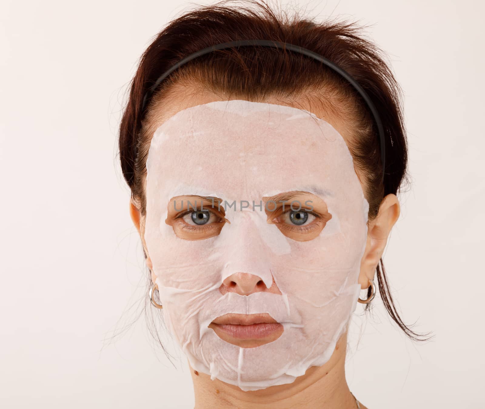 housewife woman with a sheet mask on her face by artush