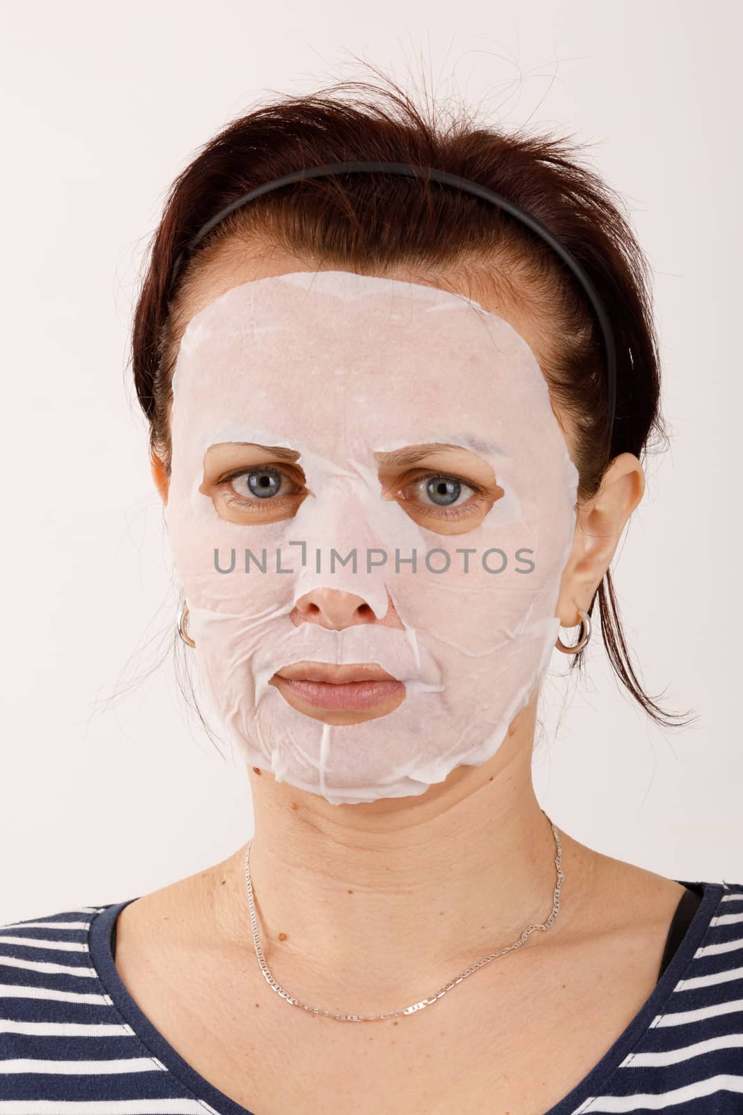 housewife woman with a sheet mask on her face by artush