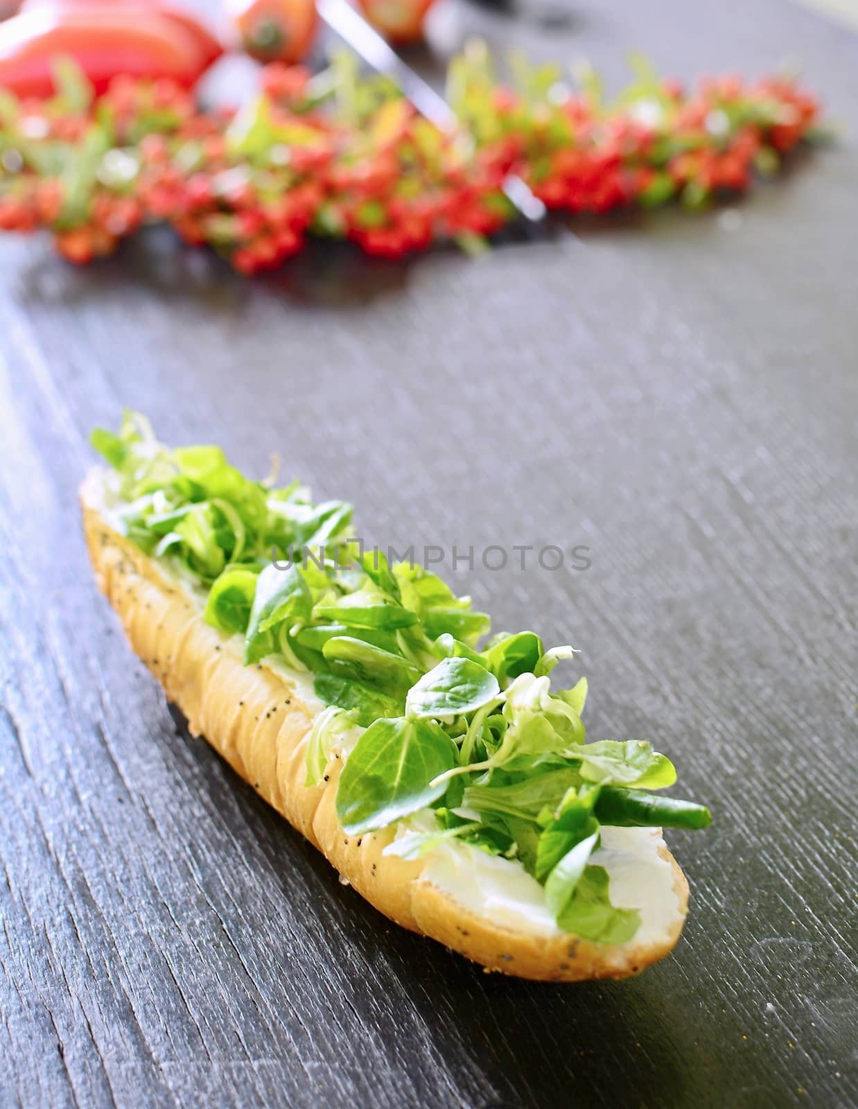 Fresh healthy white bread roll with Valerianella locusta salad.