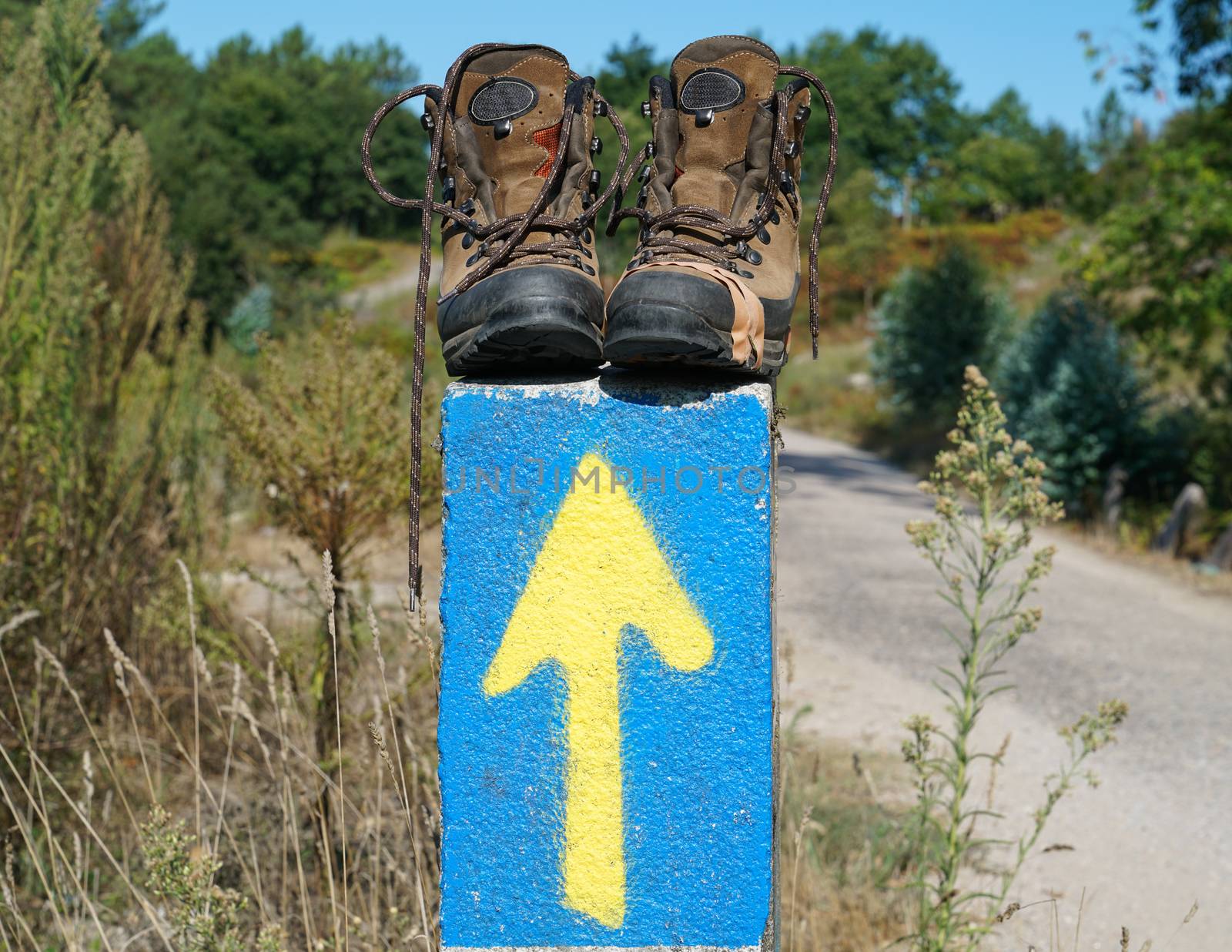 Broken walking shoes on the top of a waymark along the Way of St. James, Spain, Europe