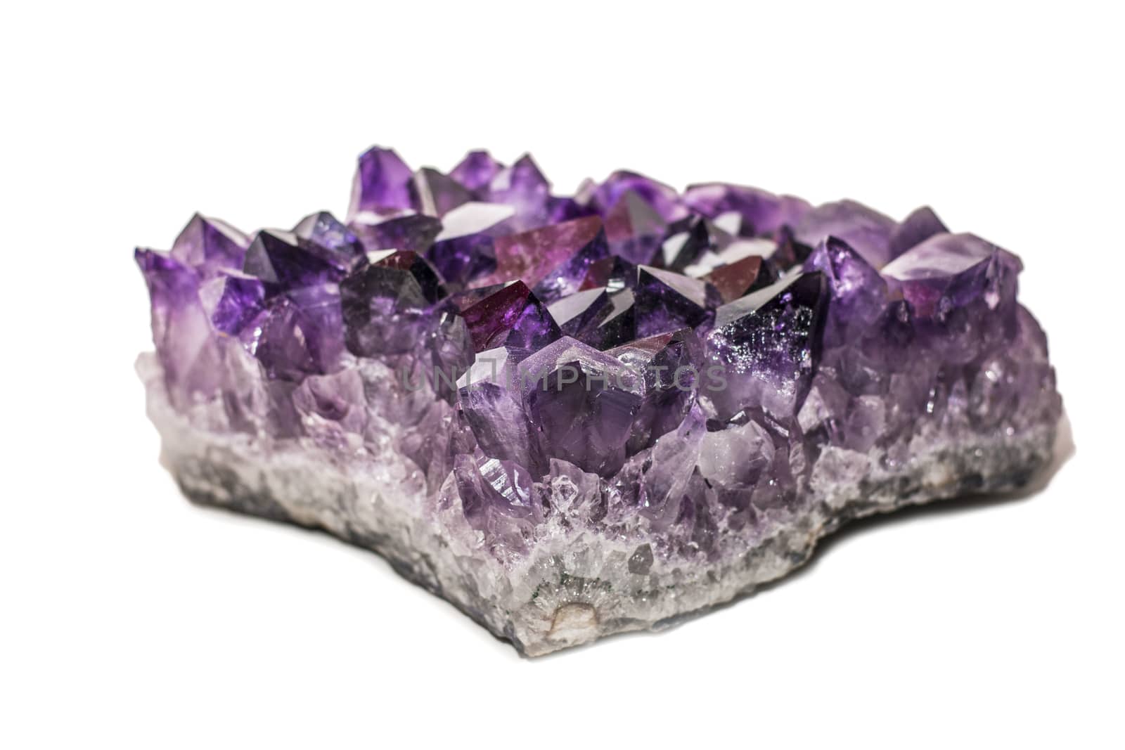 An amethyst stone placed on the white background. Horizontal studio shot.