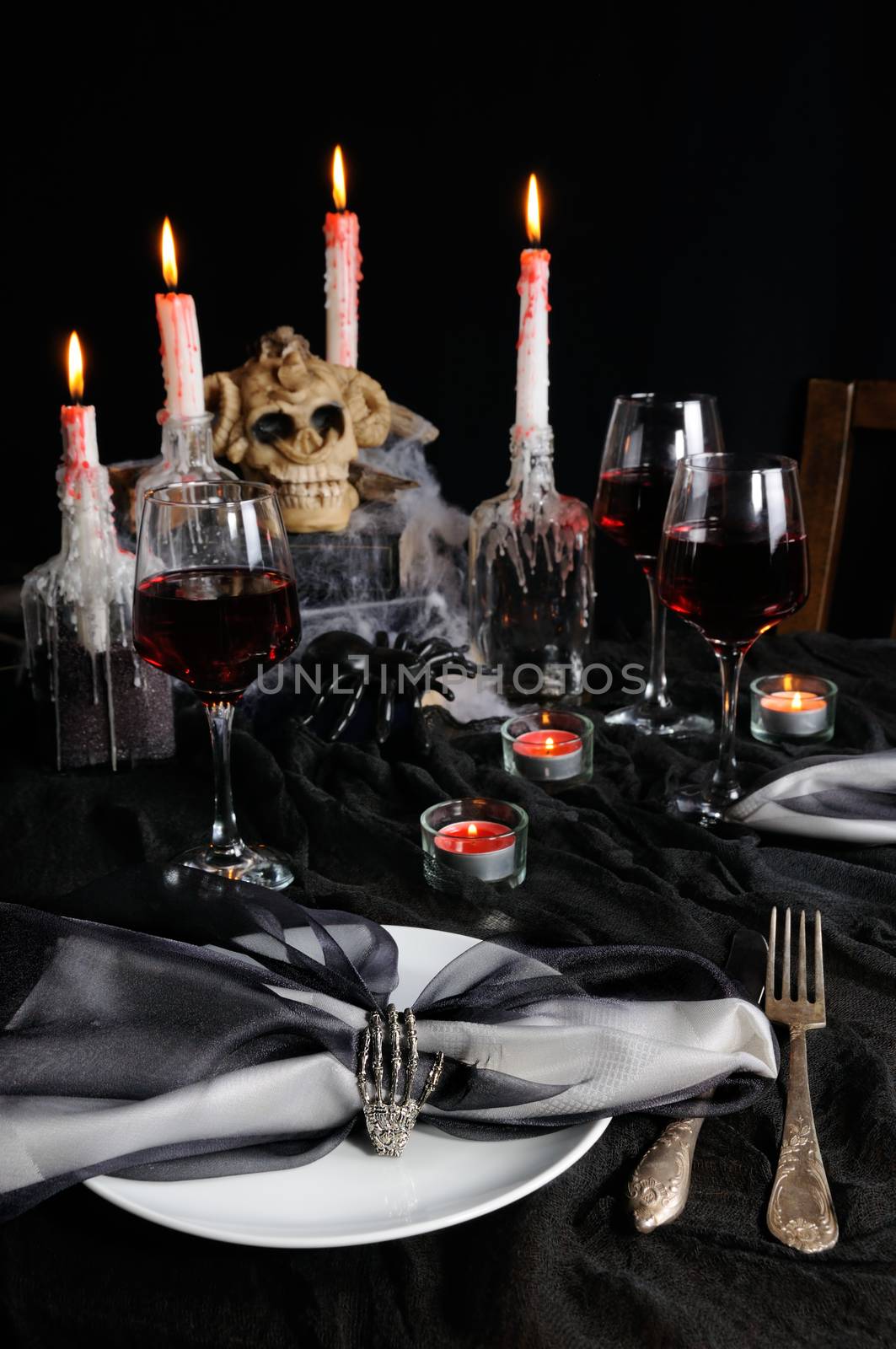 Napkin with a clip in the form of a skeleton of a brush as an element of a decor of a holiday table for Halloween