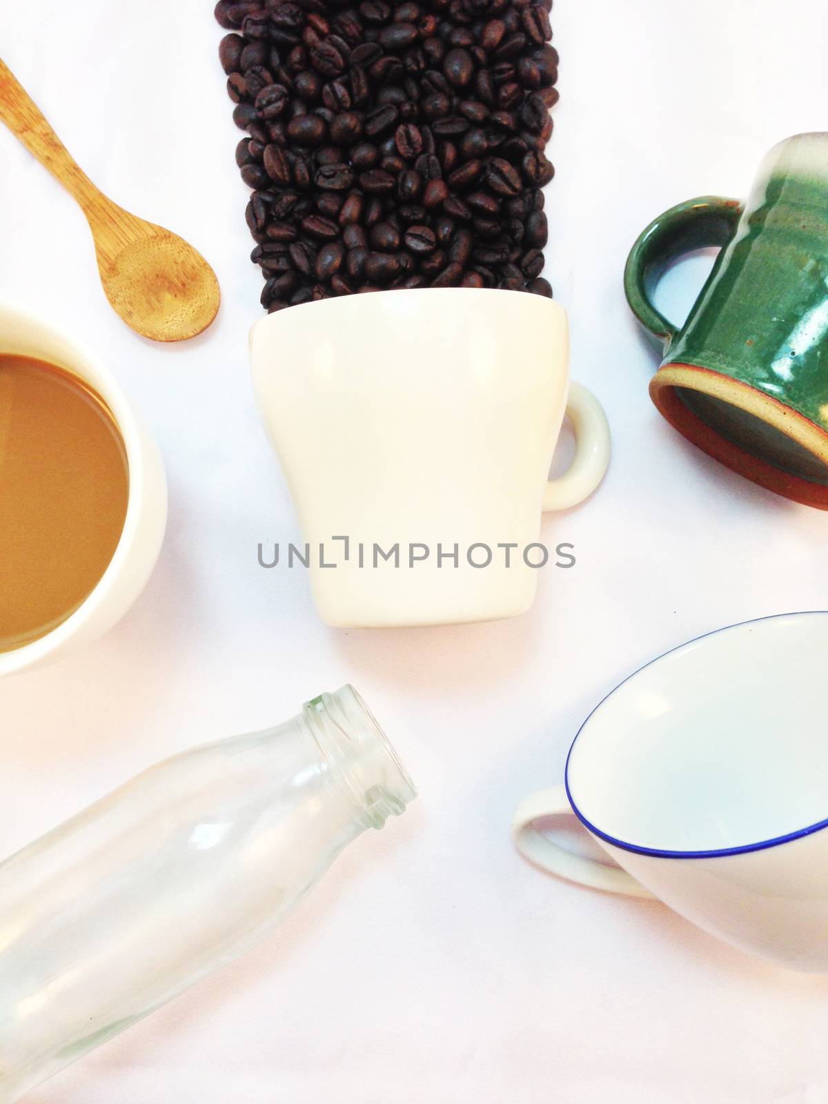 Cup of coffee, bottle and wooden spoon on white background by Bowonpat