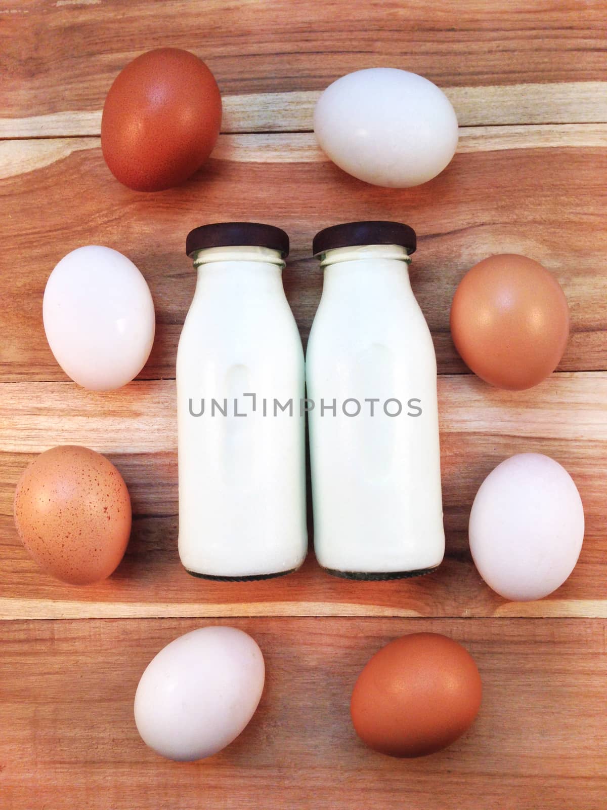 Eggs with bottle of milk on wooden background by Bowonpat