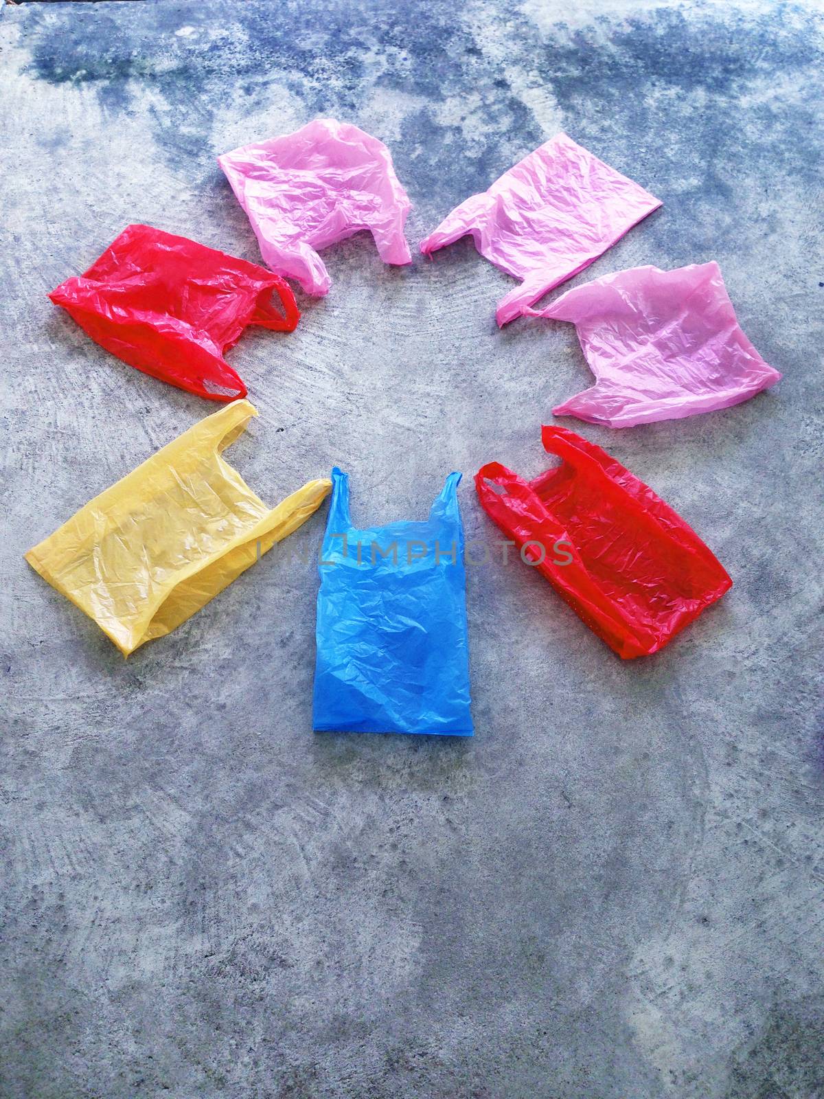 Colorful plastic bag on cement floor by Bowonpat